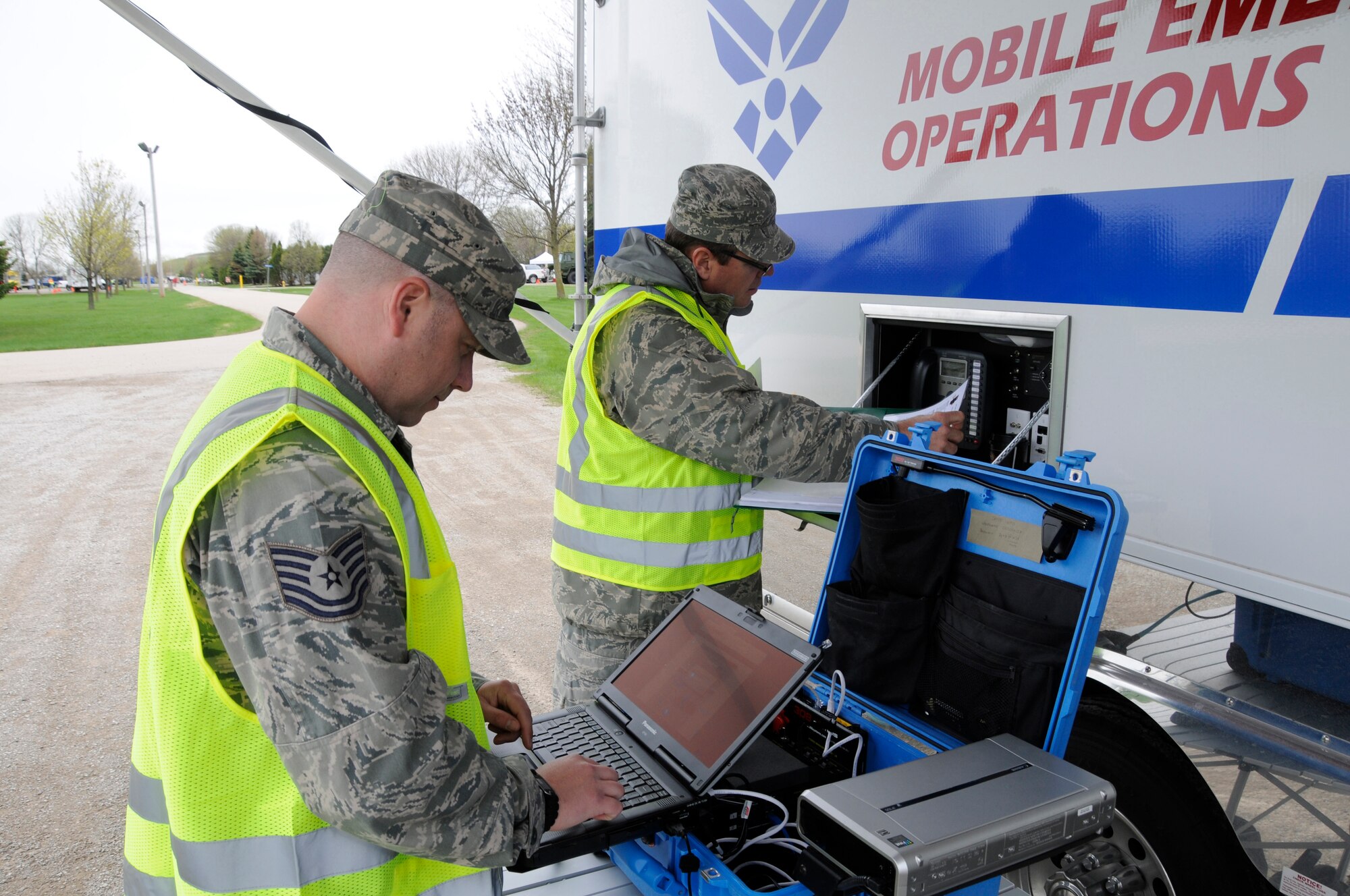 Tech. Sgt. Jamie Heinzelman (left) and Master Sgt. John Parrish, communications personnel from the 127th Wing, Michigan Air National Guard, set up a tactical communications pack (TAC PAK) outside of their Mobile Emergency Operations Center (MEOC) during SIMCOM 2014 at Sunnyview Expo Center in Oshkosh, Wis. May 15, 2014. SIMCOM (State Interoperable Mobile Communications) is a functional exercise designed to test the interoperability of federal, state, county, tribal, volunteer, private organizations and defense communications and data sharing. Air National Guard photo by Tech. Sgt. Todd Pendleton (Released)