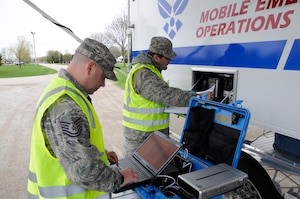 Tech. Sgt. Jamie Heinzelman (left) and Master Sgt. John Parrish, communications personnel from the 127th Wing, Michigan Air National Guard, set up a tactical communications pack (TAC PAK) outside of their Mobile Emergency Operations Center (MEOC) during SIMCOM 2014 at Sunnyview Expo Center in Oshkosh, Wis. May 15, 2014. SIMCOM (State Interoperable Mobile Communications) is a functional exercise designed to test the interoperability of federal, state, county, tribal, volunteer, private organizations and defense communications and data sharing. Air National Guard photo by Tech. Sgt. Todd Pendleton (Released)