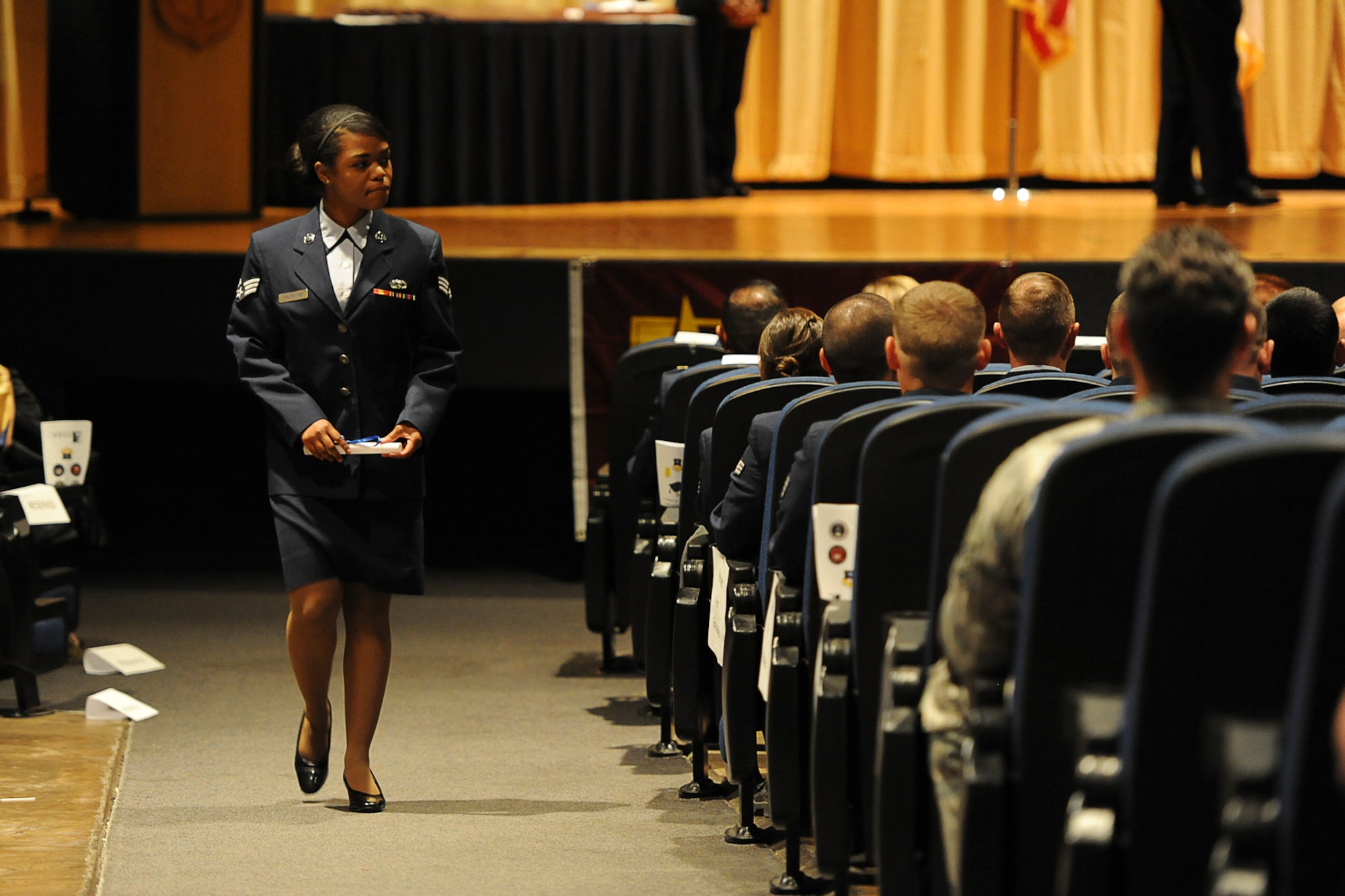GOODFELLOW AIR FORCE BASE, Texas – Senior Airman Briana N. Wilkerson, 17th Logistics Readiness Squadron Contingency Plans technician, walks back to her seat after receiving her Community College of the Air Force graduation certificate at the base theater here May 16. It takes an average of two years to receive a CCAF degree if classes are consistently taken. (U.S. Airman 1st Class Devin Boyer)