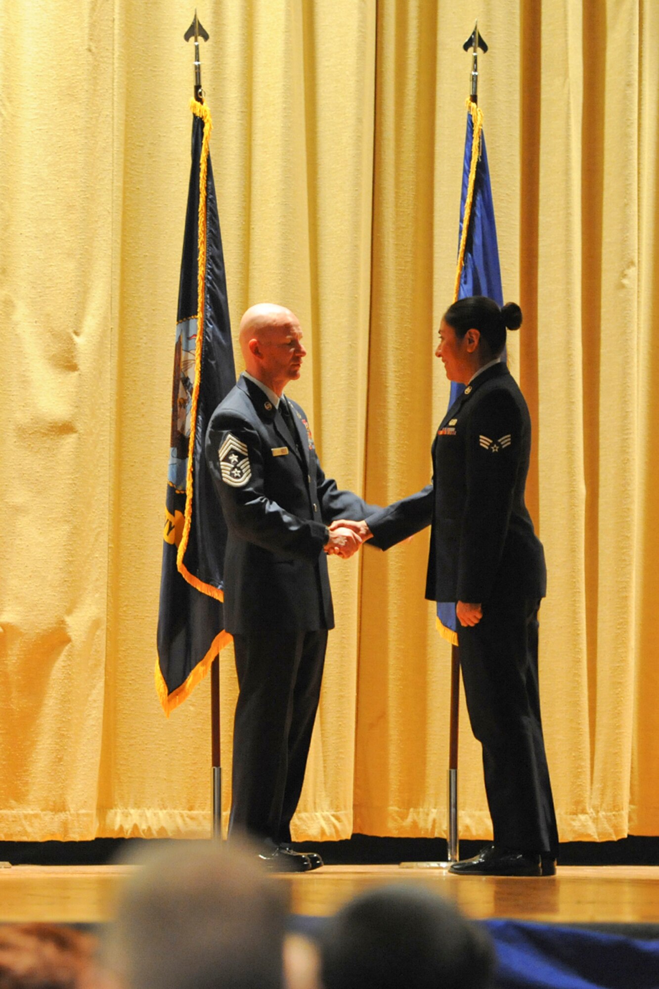 GOODFELLOW AIR FORCE BASE, Texas – Chief Master Sgt. Thomas F. Good, 17th Training Wing Command Chief, shakes hands with Senior Airman Rachel N. Salazar, 17th Communications Squadron commercial communications technician, during the Community College of the Air Force and Park University graduation at the base theater here May 16. According to Air University's website, service members complete approximately 1.6 million semester hours of course credit through CCAF affiliated schools each year. (U.S. Air Force photo/ Airman 1st Class Devin Boyer)