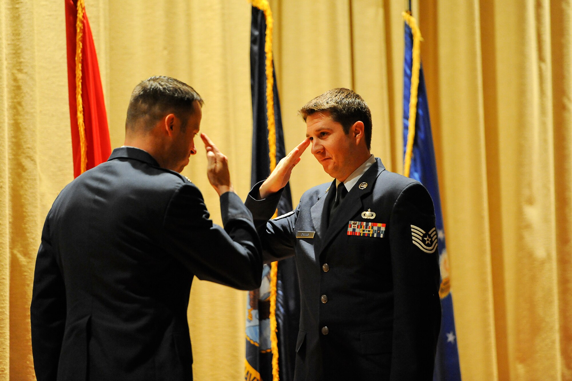 GOODFELLOW AIR FORCE BASE, Texas – Tech. Sgt. Stephen J. Davies, 315th Training Squadron instructor supervisor, salutes Col. Thomas L. Schmidt, 17th Training Wing Vice Commander, during the Community College of the Air Force and Park University graduation at the base theater here May 16. The CCAF offers job-related associate degrees in applied science and other academic credentials that enhance mission readiness. (U.S. Air Force photo/ Airman 1st Class Devin Boyer)