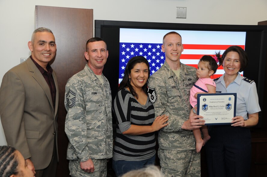 Air Force District of Washington Commander Maj. Gen. Sharon K. G. Dunbar, AFDW Command Chief Master Sgt. Jose LugoSantiago and AFDW First Sergeant Senior Master Sgt. Johnny Hamm present a Stripes for Exceptional Performers promotion for the rank of master sergeant to Tech. Sgt. Brad Gurley as he stands with wife Nicole and daughter Gabriela at Joint Base Andrews, Md., May 21, 2014. A STEP promotion is used by commanders to recognize exceptional performers by immediately awarding them the next rank. Gurley is the executive assistant to the AFDW command chief. (U.S. Air Force photo/Staff Sgt. Matt Davis)