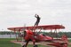 Carol Pilon celebrates a successful performance from atop her 1940 Boeing-Stearman aircraft here, May 18, 2014. Pilon performed on the wings of the aircraft, piloted by Marcus Payne, as part of the 2014 Thunder Over the Valley Air Show and Open House, hosted here May 17-18. Pilon began wing-walking in 2001 and founded Third Strike Wingwalking in 2004 with the goal of inspiring young people to pursue aviation. U.S. Air Force photo/Senior Airman Rachel Kocin.