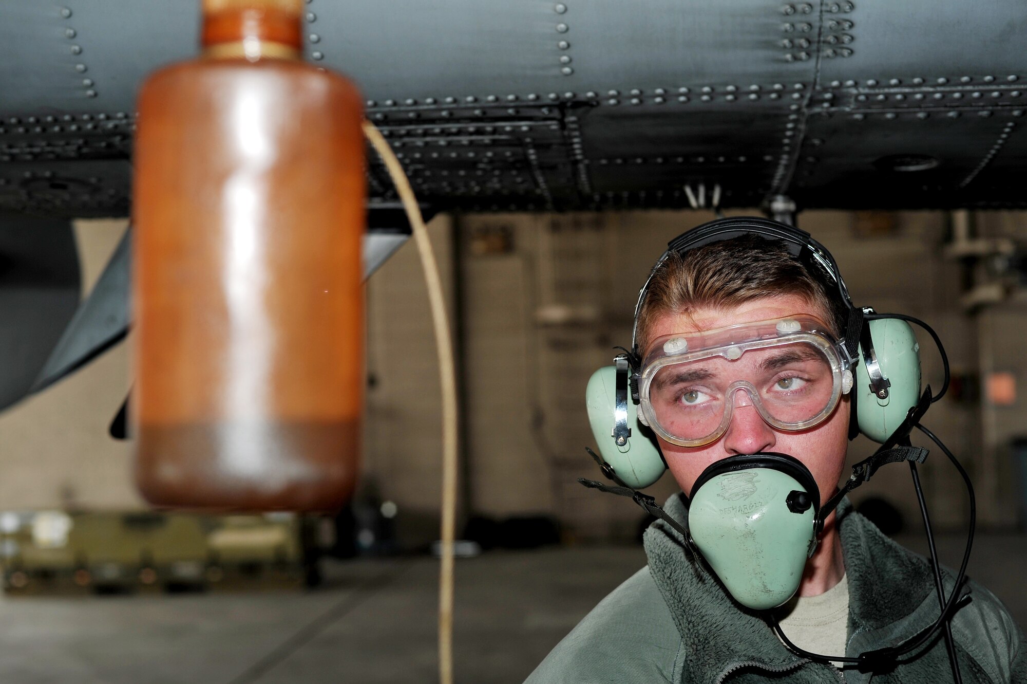 U.S. Air Force Airman 1st Class Austin Hall, 355th Aircraft Maintenance Squadron crew chief from Davis-Monthan Air Force Base, Ariz., drains fuel from an A-10 Thunderbolt II during RED FLAG-Alaska 14-1 May 20, 2014, Eielson Air Force Base, Alaska.  Crew chiefs ensure the quality of oil is at its prime before and after every flight. (U.S. Air Force photo by Staff Sgt. Jim Araos)