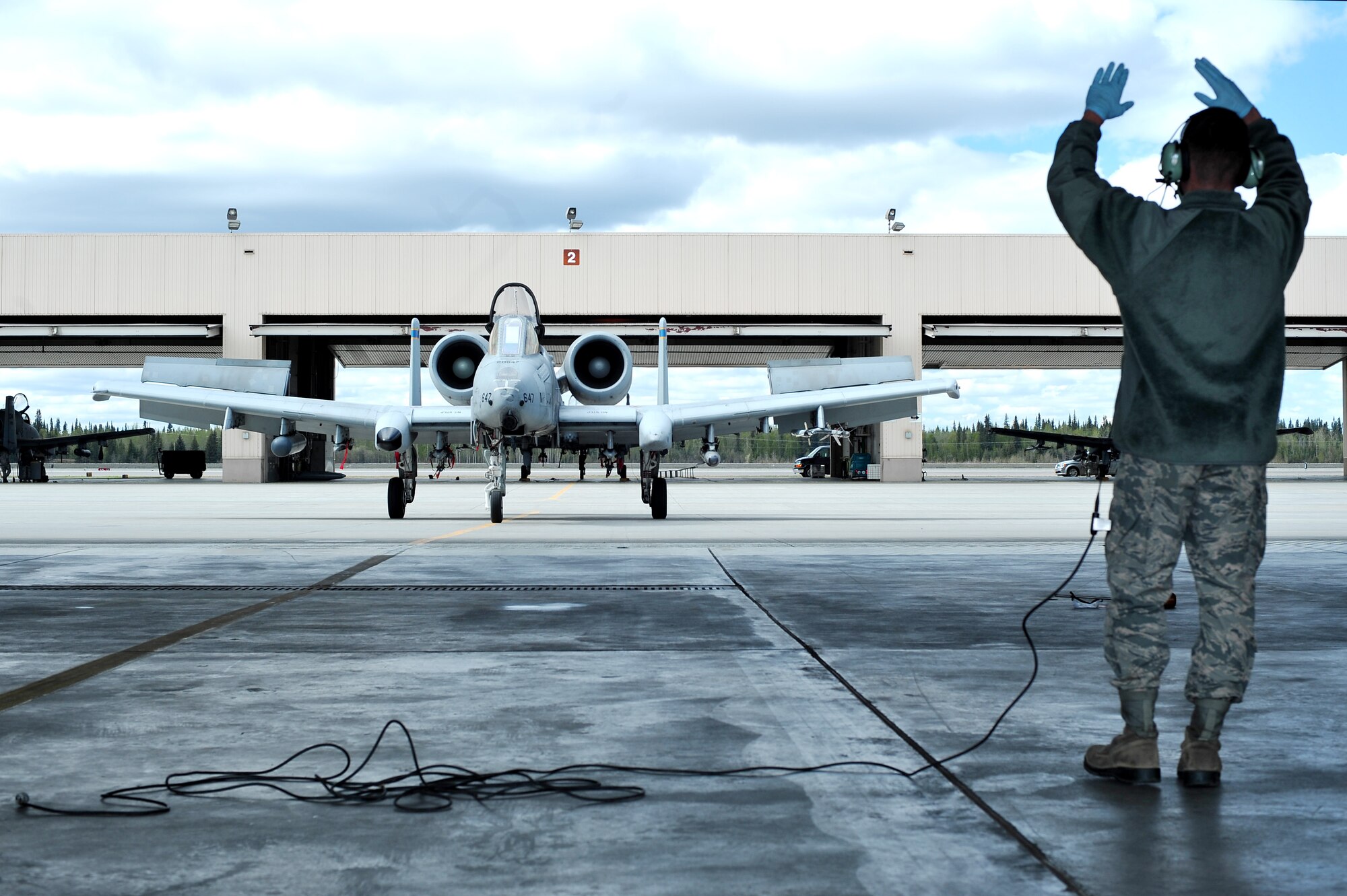 U.S. Air Force Airman 1st Class Austin Hall, 355th Aircraft Maintenance Squadron crew chief from Davis-Monthan Air Force Base, Ariz., marshals an A-10 Thunderbolt II during RED FLAG-Alaska 14-1 May 20, 2014, Eielson Air Force Base, Alaska.  A-10s are simple, effective and survivable twin-engine jet aircraft that can be used against all ground targets, including tanks and other armored vehicles. (U.S. Air Force photo by Staff Sgt. Jim Araos)