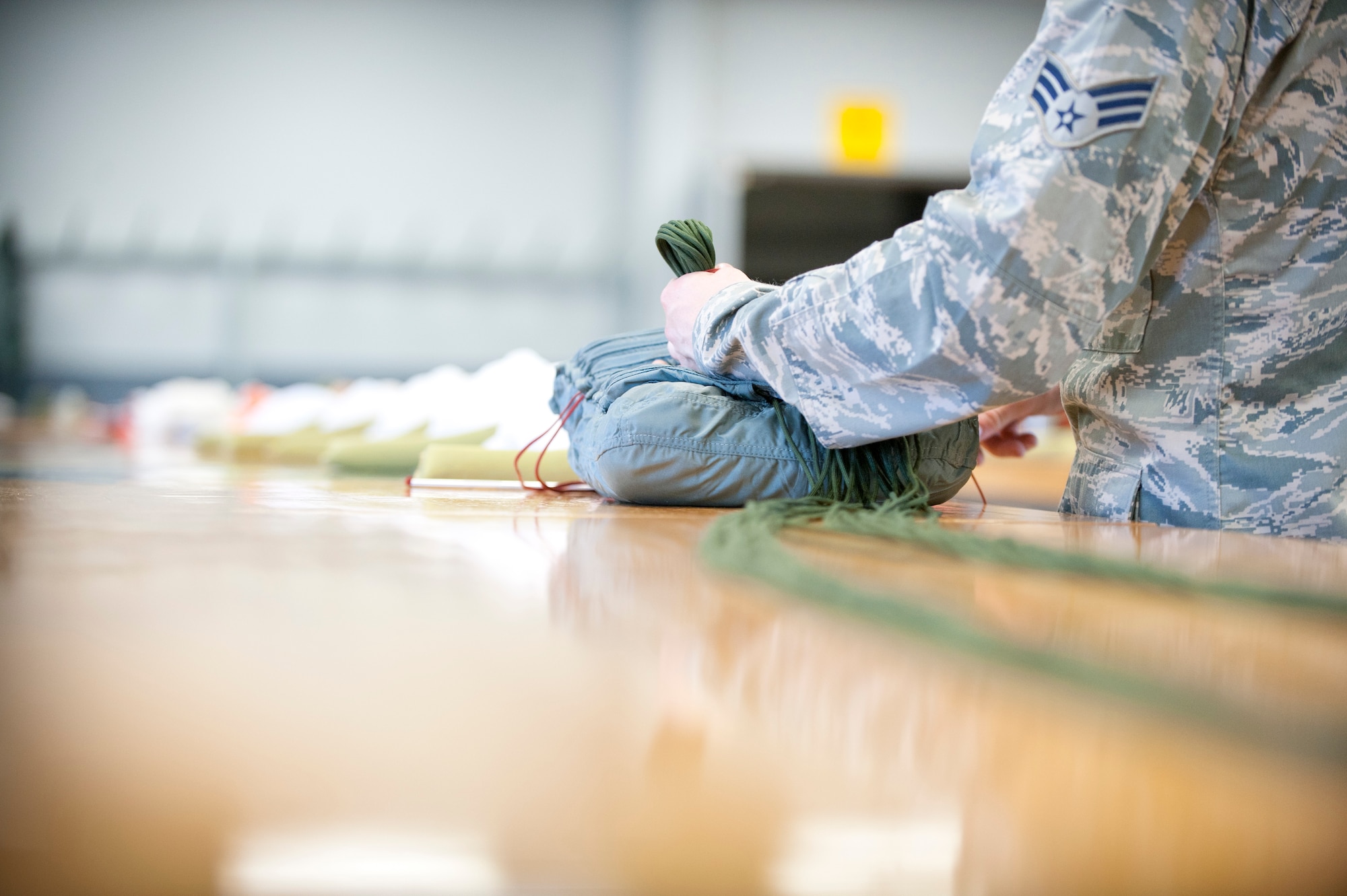 Senior Airman Ethan Brenker, 1st Special Operations Support Squadron aircrew flight equipment journeyman, stores suspension lines on a back-automartic personnel parachute at the AFE shop on Hurlburt Field, Fla., May 20, 2014. Back-automatic personnel parachutes are used in emergency situations. (U.S. Air Force photo/Senior Airman Krystal M. Garrett) 