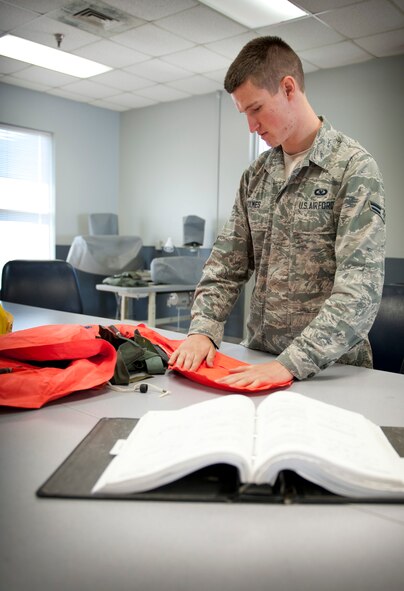Airman 1st Class Tyler Holmes, 1st Special Operations Support Squadron aircrew flight equipment apprentice, inspects a life preserver unit at the AFE shop on Hurlburt Field, Fla., May 20, 2014. The 1st SOSS AFE shop inspects and packs about 100 LPUs a month. (U.S. Air Force photo/Senior Airman Krystal M. Garrett) 