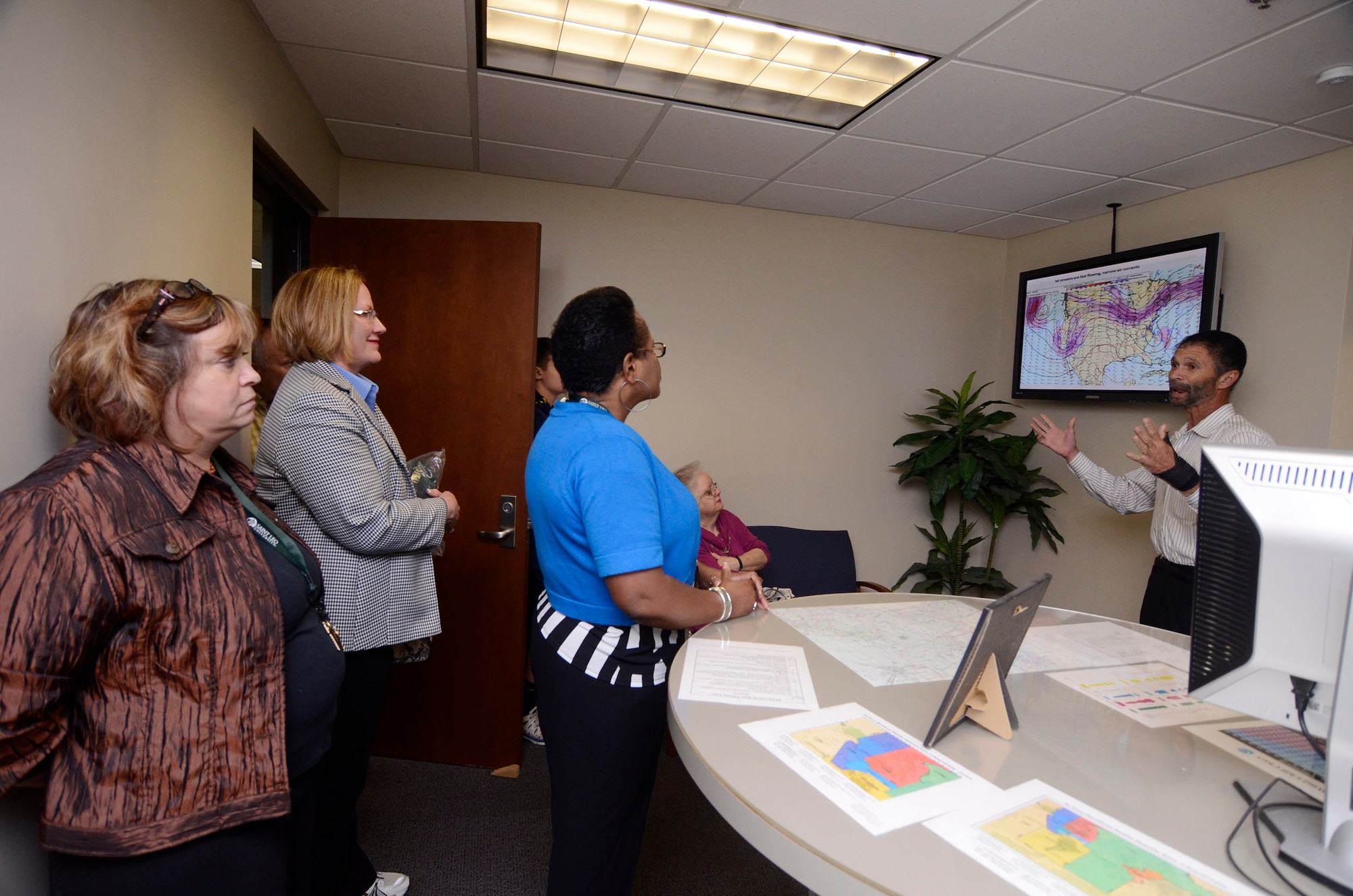 Saint Leo University Marietta Center staff members, Dietlinde Dial, academic advisor, Mary Estes, director, Wanda Easton, assistant director of admissions, and Diana Ehlers, staff assistant, receive a weather brief by John Ridley, 94th Operations Group meteorologist, during a tour of Dobbins Air Reserve Base, Ga. May 19, 2014. University Staff members spoke with personnel from the 94th Security Forces Squadron, 94th OG, Explosive Ordnance Disposal members, and the 700th Airlift Squadron, learning about organizational missions. (U.S. Air Force photo/Don Peek)