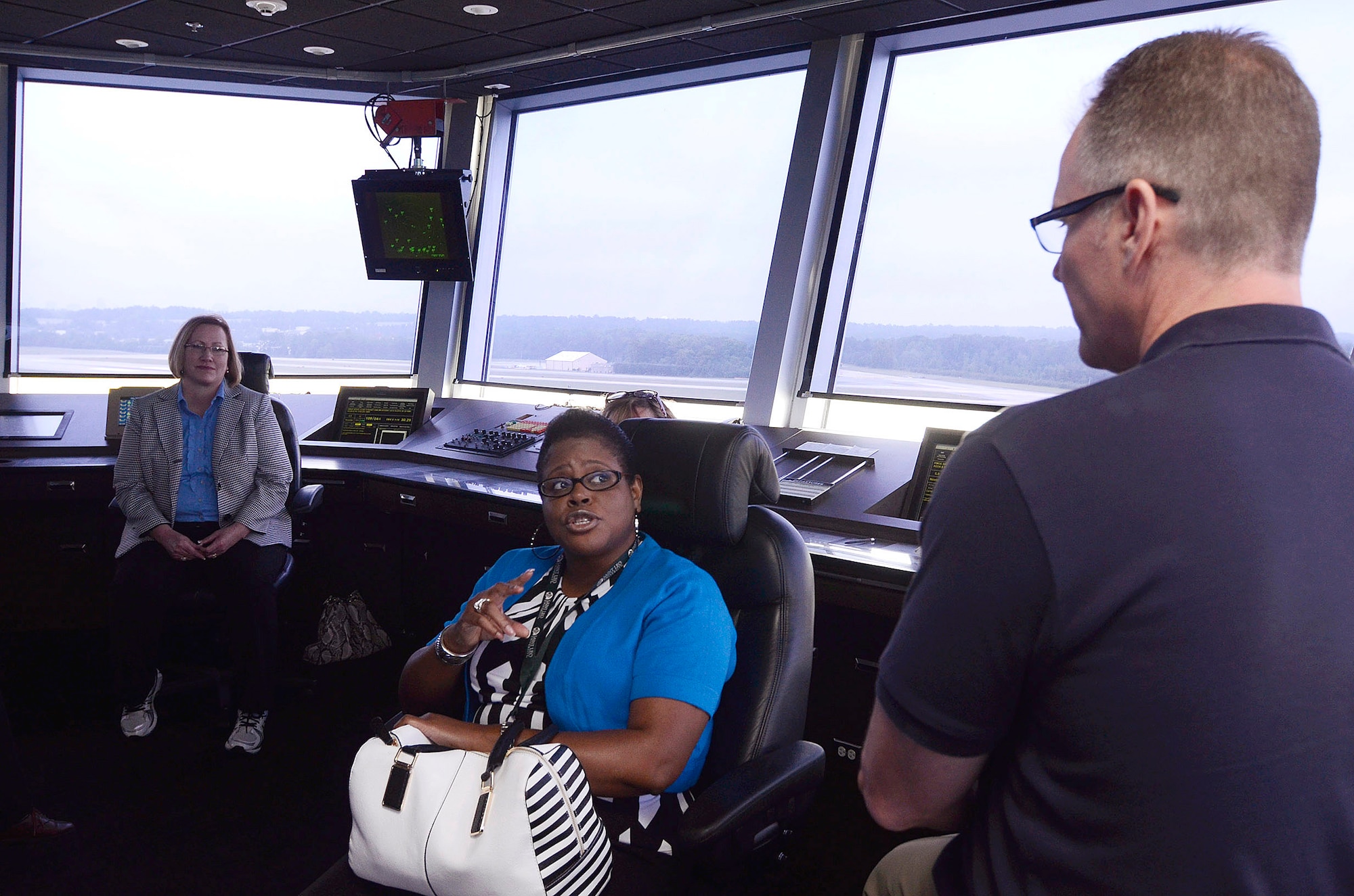 Wanda Easton, assistant director of admissions from Saint Leo University Marietta Center, visits with Henry Vonruden, 94th Operations Group, air traffic controller during a tour of Dobbins Air Reserve Base, Ga. May 19, 2014. University Staff members spoke with personnel from the 94th Security Forces Squadron, 94th OG, Explosive Ordnance Disposal members, and the 700th Airlift Squadron, learning about organizational missions. (U.S. Air Force photo/Don Peek)