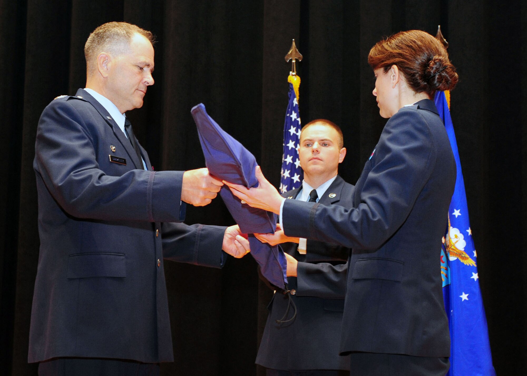 WRIGHT-PATTERSON AIR FORCE BASE, Ohio – Col. Douglas Drakeley, 655th Intelligence, Surveillance and Reconnaissance Group commander, hands Lt. Col. Dianne Hickey, 14th Intelligence Squadron commander, the 14 IS guidon to unfurl as part of the 14 IS activation ceremony May 17. Unfurling the guidon signifies the activation and future of the unit. (Courtesy photo)
