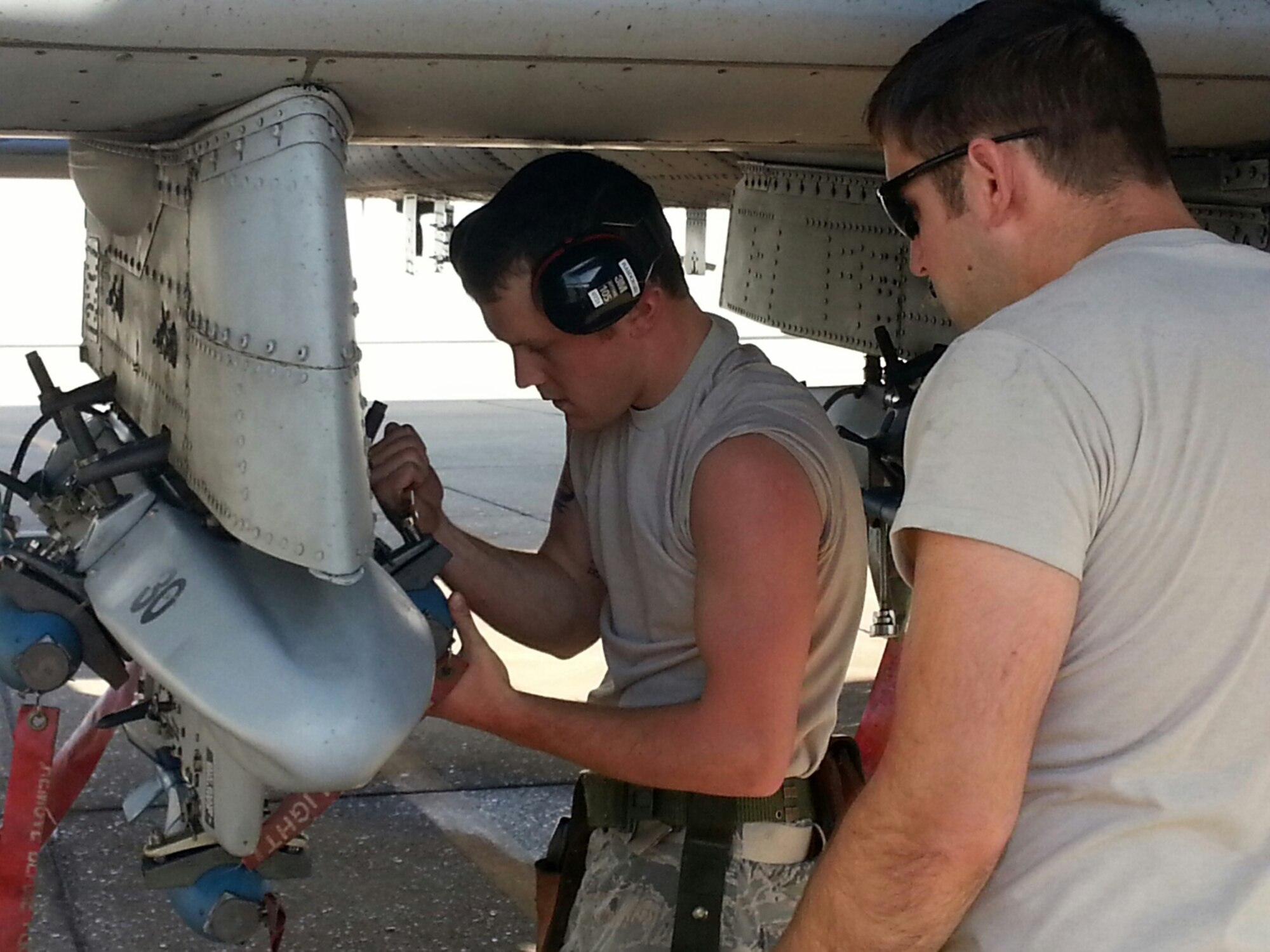 Senior Airman Dustin Flaspohler, left, and Tech Sgt. Charley Parker, both weapons specialists with the 188th Aircraft Maintenance Squadron, load BDU-33s on an A-10C Thunderbolt II “Warthog” May 4, 2014, at Ebbing Air National Guard Base, Fort Smith, Arkansas. This was the final BDU load at the 188th Fighter Wing. The 188th is currently converting from a fighter mission to a remotely piloted aircraft, space-focused targeting and intelligence, surveillance and reconnaissance mission. (Courtesy photo/released)