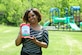 LaShanda Jones, holds a copy of her first published childrens' book, "Kele Vorel and Courtney Queen" on May 19, 2014, in front of the Joint Base Andrews, Md.,459th Air Refueling Wing playground. Jones, a retired Air Force veteran, is the chief of finance at the wing. (U.S. Air Force photo / Amber J. Russell)