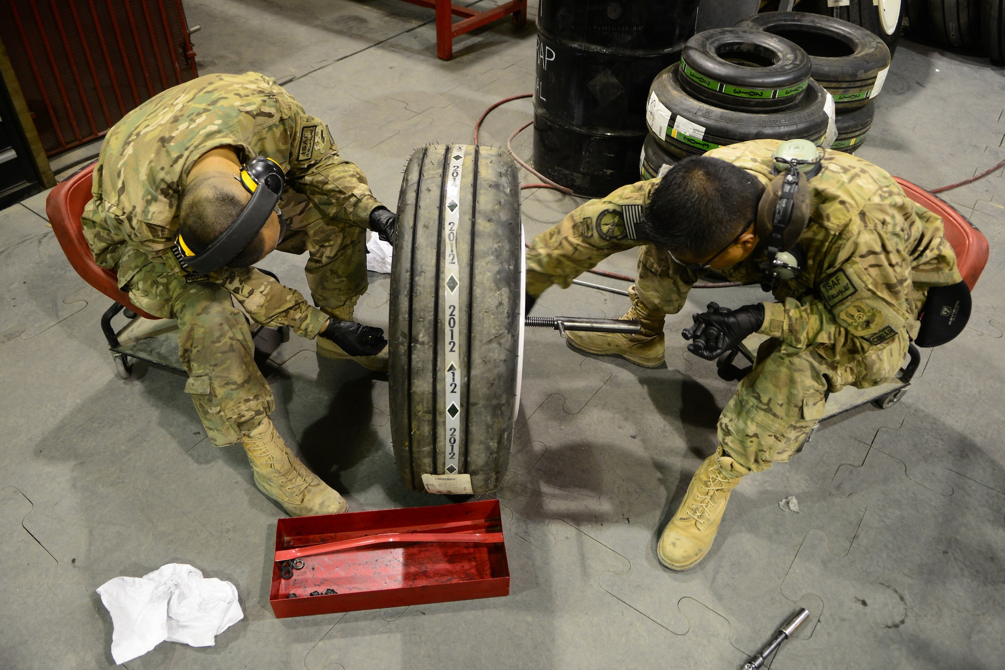 (From left) Staff Sgt. John Dang, 455th Expeditionary Maintenance Squadron crash recovery team member and Tech Sgt. Rodney Transfiguracion, 455th EMXS crash recovery team chief, assemble a wheel and tire May 19, 2014.  As part of the wheel and tire shop, Transfiguracion ensures serviceable tires are readily available for A-10 Thunderbolt IIs and F-16 Fighting Falcons, as part of their process the shop breaks tires down to the bearing, clean the components and wash all wheels.  Tranfiguracion and Dang are deployed from Whiteman Air Force Base, Mo. Transfiguracion is native of Whittier, Calif. and Dang is a native of Overland Park, Kan.  (U.S. Air Force photo by Staff Sgt. Evelyn Chavez/Released)
