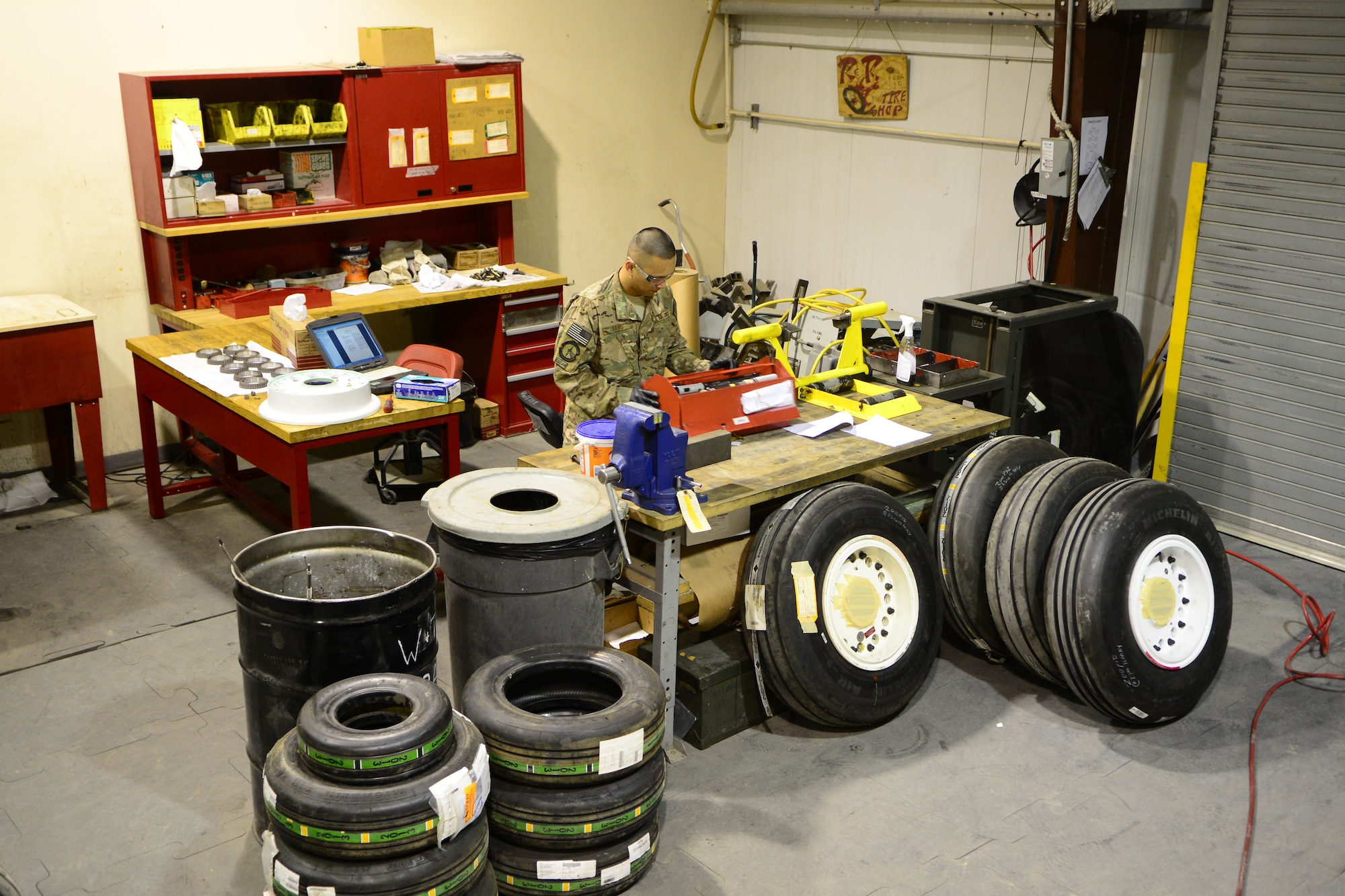 Staff Sgt. John Dang, 455th Expeditionary Maintenance Squadron crash recovery team member, prepares his tools before a wheel and tire assembly May 19, 2014.  As part of the wheel and tire shop, Dang ensures serviceable tires are readily available for A-10 Thunderbolt IIs and F-16 Fighting Falcons, as part of their process the shop breaks tires down to the bearing, clean the components and wash all wheels. Dang is deployed from Whiteman Air Force Base, Mo. and a native of Overland Park, Kan.  (U.S. Air Force photo by Staff Sgt. Evelyn Chavez/Released)