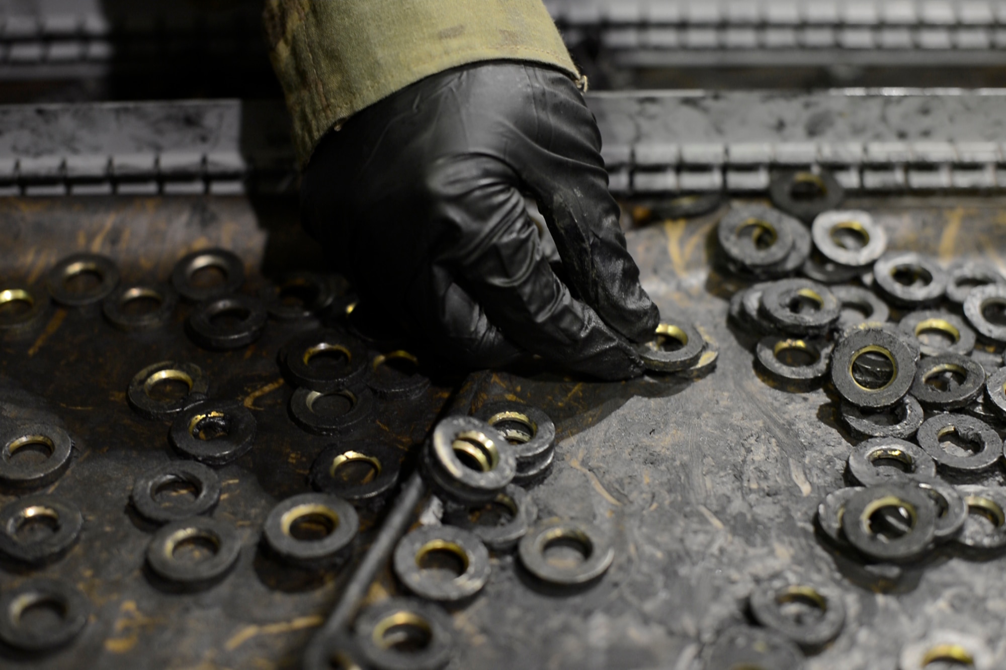 Staff Sgt. John Dang, 455th Expeditionary Maintenance Squadron crash recovery team member, picks up washers for a wheel during a wheel and tire assembly May 19, 2014 at Bagram Airfield, Afghanistan.  As part of the wheel and tire shop, Dang provides serviceable tires for A-10 Thunderbolt IIs and F-16 Fighting Falcons, the repairs on an average of 48 wheels per month.  Dang is deployed from Whiteman Air Force Base, Mo. and a native of Overland Park, Kan.  (U.S. Air Force photo by Staff Sgt. Evelyn Chavez/Released)