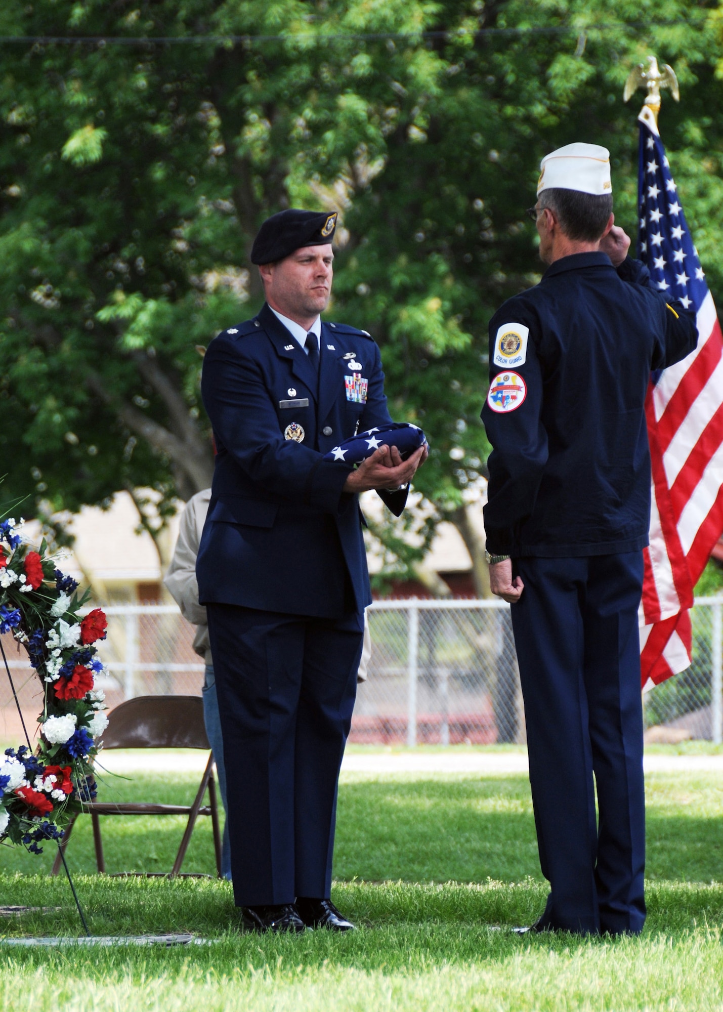 Lt. Col. Christopher Nieman, commander of the 509th Security Forces Squadron, Whiteman Air Force Base, Mo., holds the folded flag as Joe Cochran, Veterans of Foreign Wars Post 2591, salutes during an Armed Forces Day ceremony May 17, 2014, in Sedalia, Mo. Nieman and more than 50 Airmen of the 509th SFS stood alongside family members of 2nd Lt. George A. Whiteman, Sedalia Veterans and cadets, and community members. (U.S. Air National Guard photo by Senior Airman Nathan Dampf/Released)