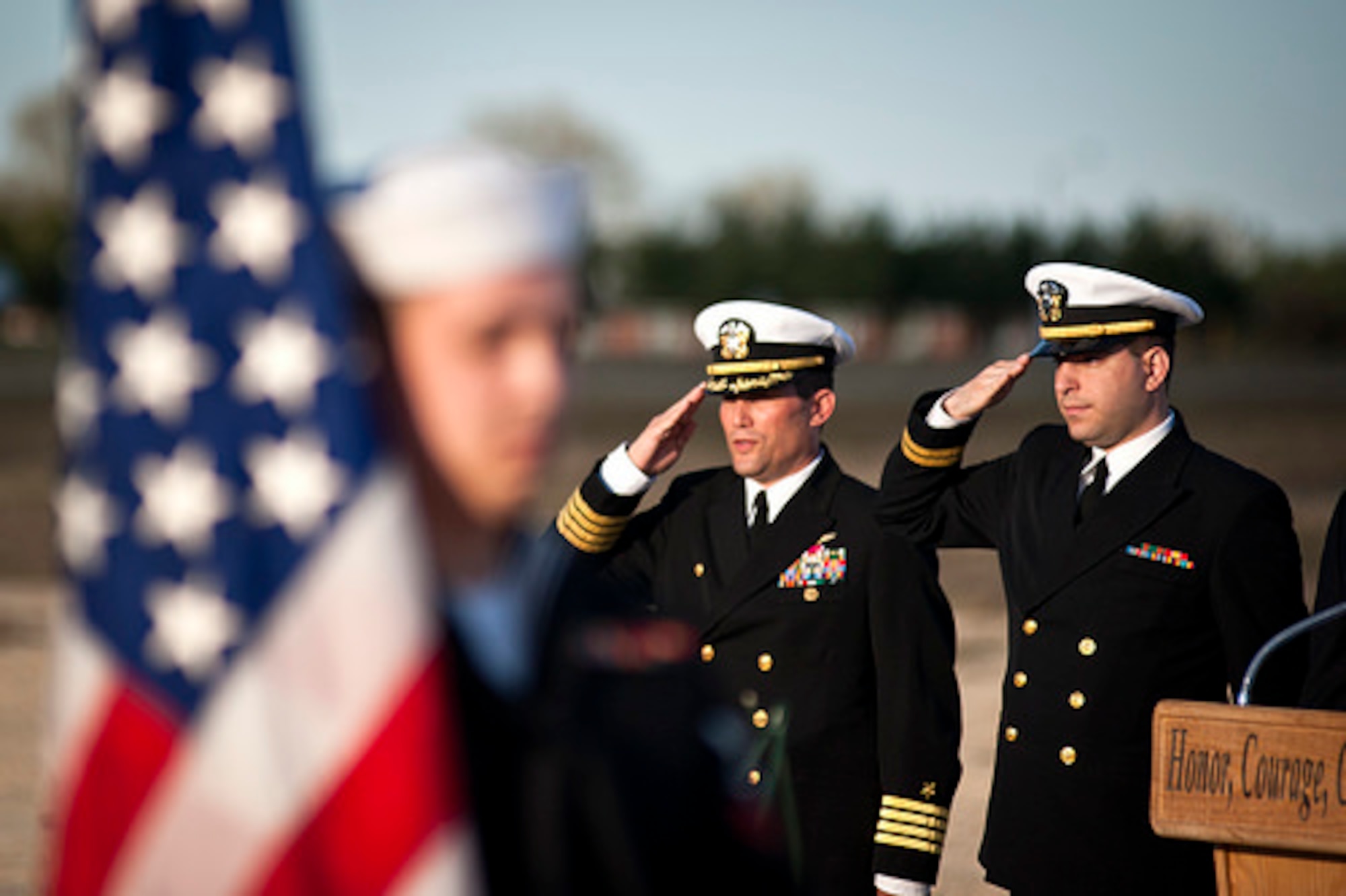 Navy Capt. Christopher Fletcher, Joint Base McGuire-Dix-Lakehurst deputy commander, and Navy Chaplain Lt. Brett Sabella, 87th Air Base Wing chaplain, salute as a color guard retires the colors during the annual Hindenburg Memorial Ceremony May 6, 2014, at JB MDL, N.J. The event was in honor of the 77th anniversary of the tragic Hindenburg airship accident here that claimed the lives of 39 people May 6, 1937. (U.S. Air Force photo by Staff Sgt. Scott Saldukas/Released)  