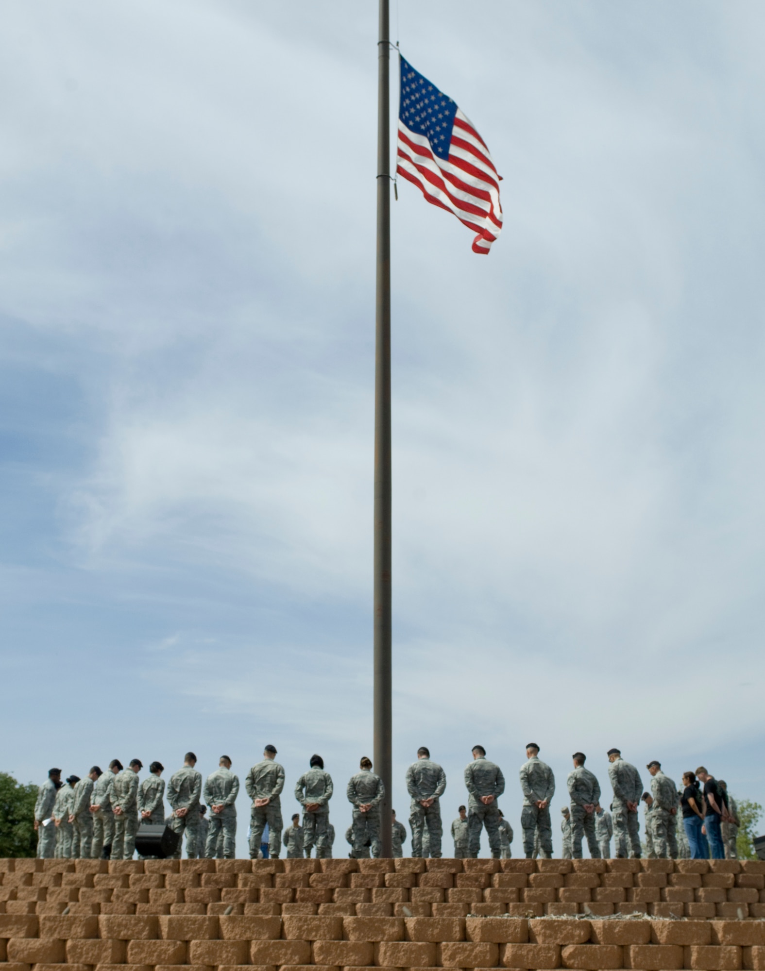 Airmen from the 7th Security Forces Squadron gather for a moment of silence around the flag pole May 16, 2014, at Dyess Air Force Base, Texas. The moment of silence was held during National Police Week to honor fallen law enforcement officers and fellow Airmen who have given their lives in the line of duty. (U.S. Air Force photo by Airman 1st Class Kylsee Wisseman/Released)
