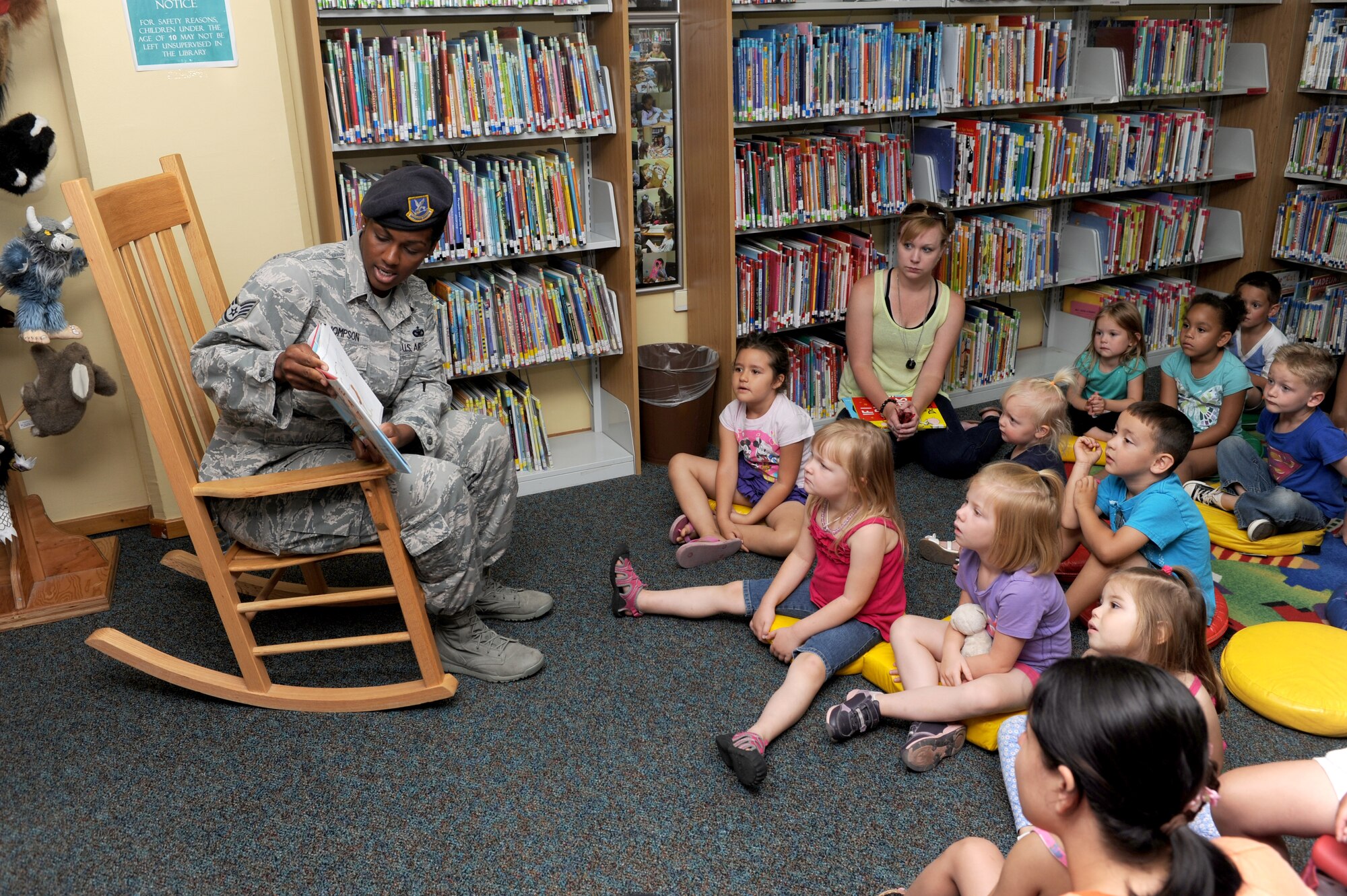 Staff Sgt. Ebony Thompson, 39th Security Forces Squadron NCO in-charge of police services, reads to children at the base library May 20, 2014, Incirlik Air Base, Turkey. Thompson and other 39th SFS members read to children as part of National Police Week events. (U.S. Air Force photo by Tech. Sgt. Dallas Edwards/Released)