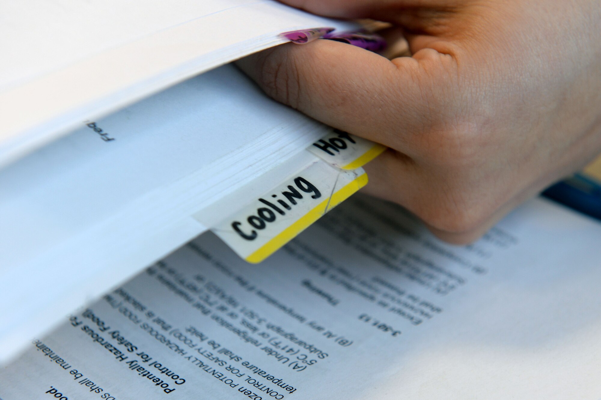 U.S. Air Force Senior Airman Misty Warner, 52nd Aerospace Medicine Squadron Public Health food safety and sanitation technician from Oglesby, Texas, references the Food and Drug Administration food code to complete a report after a monthly health inspection at the Eifel Mountain Golf Course at Spangdahlem Air Base, Germany, May 20, 2014. Following an inspection, inspectors compile all findings into a report for both public health record and for the establishment. (U.S. Air Force photo by Senior Airman Alexis Siekert/Released)