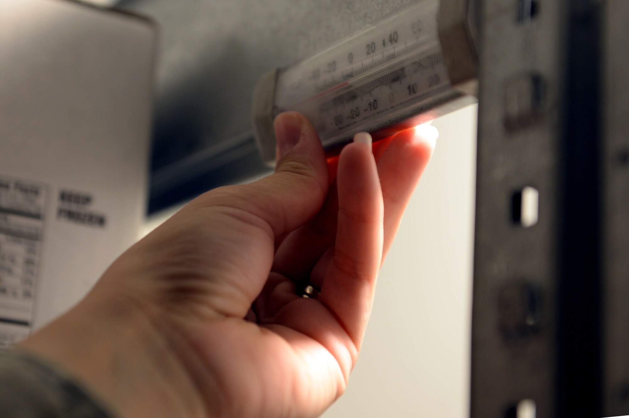 U.S. Air Force Senior Airman Misty Warner, 52nd Aerospace Medicine Squadron Public Health food safety and sanitation technician from Oglesby, Texas, checks the internal temperature of a freezer during a monthly health inspection at the Eifel Mountain Golf Course at Spangdahlem Air Base, Germany, May 20, 2014. Different food items must be kept at the proper temperatures to ensure their freshness. (U.S. Air Force photo by Senior Airman Alexis Siekert/Released)