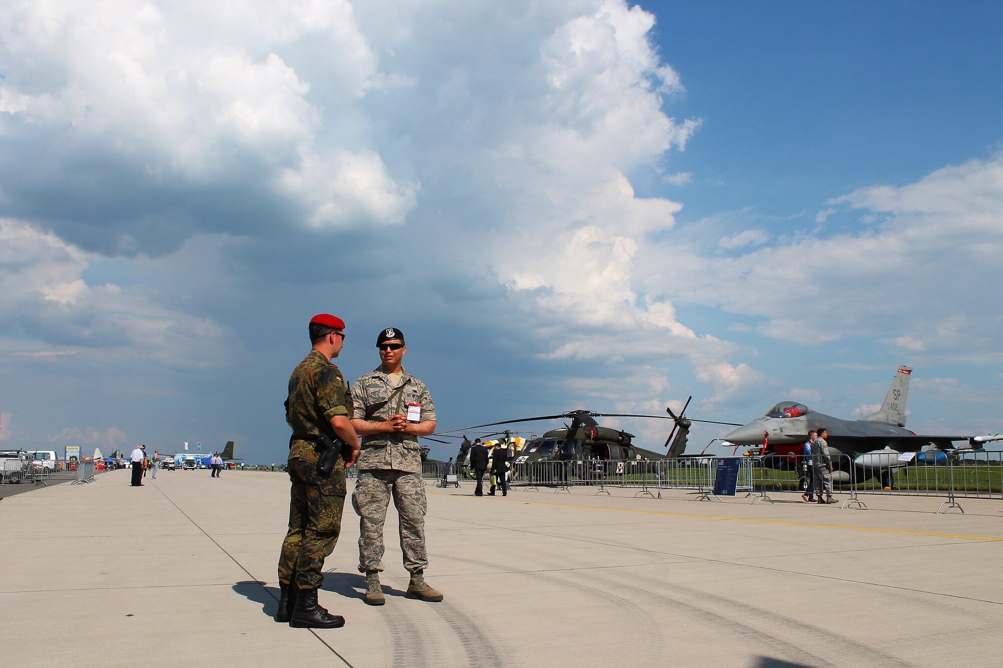 U.S. Air Force Airman 1st Class Jeremy Smith, Security Forces member, speaks with a German security forces peer at this year’s Berlin Trade and Air Show, Berlin, May 20, 2014.  The first three days of the show are dedicated to displaying the latest developments and products in the aerospace industry to spectators or visitors.  The last three days of the show are dedicated to inviting the public out to display the aircraft and technologies of each participating nation and to enjoy the aerial demonstrations being put on by participating nations. (U.S. Air Force photo/ 2nd Lt. Clay Lancaster)