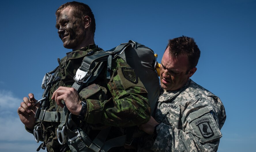 Army Sgt. Zachary McCarter, 1st Battalion 503rd Airborne Infantry Regiment forward observer, an Oakland, California native, helps Lithuanian Land Forces Crpl. Ramūnas Zimblys prepare his parachute at Šiauliai International Airport, Lithuania, May 17, 2014. Pilots and loadmasters from the 37th AS, alongside an 86th Aircraft Maintenance flying crew chief spent four days across three Baltic countries assisting in personnel drops of allied partners and American service members. (U.S. Air Force photo/Airman 1st Class Jordan Castelan)