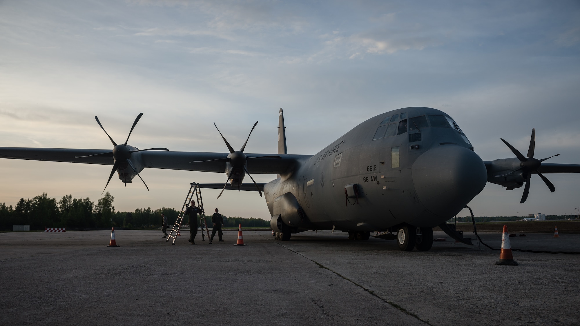 Senior Airman Austin Koester, 37th Airlift Squadron loadmaster, a Murdo, South Dakota native, moves a ladder in place to help Tech. Sgt. Francis Gilson, 86th Aircraft Maintenance Squadron crew chief, an Andersonville, Tennesse native, with engine maintenance on Riga International Airport, Latvia, May 17, 2014. Pilots and loadmasters from the 37th AS, alongside an 86th Aircraft Maintenance flying crew chief spent four days across three Baltic countries assisting in personnel drops of allied partners and American service members. (U.S. Air Force photo/Airman 1st Class Jordan Castelan)