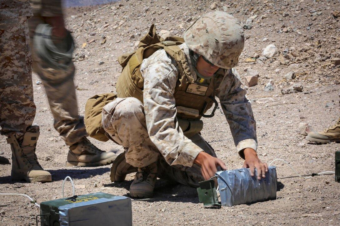 Marine Corps Lance Cpl. Carlos M. Hernandez, center, readies an expedient field claymore at a live-fire training range during Exercise Desert Scimitar 2014 on Marine Corps Air Ground Combat Center Twentynine Palms, Calif., May 13, 2014. Hernandez, a combat engineer, is assigned to 3rd Combat Engineer Battalion.