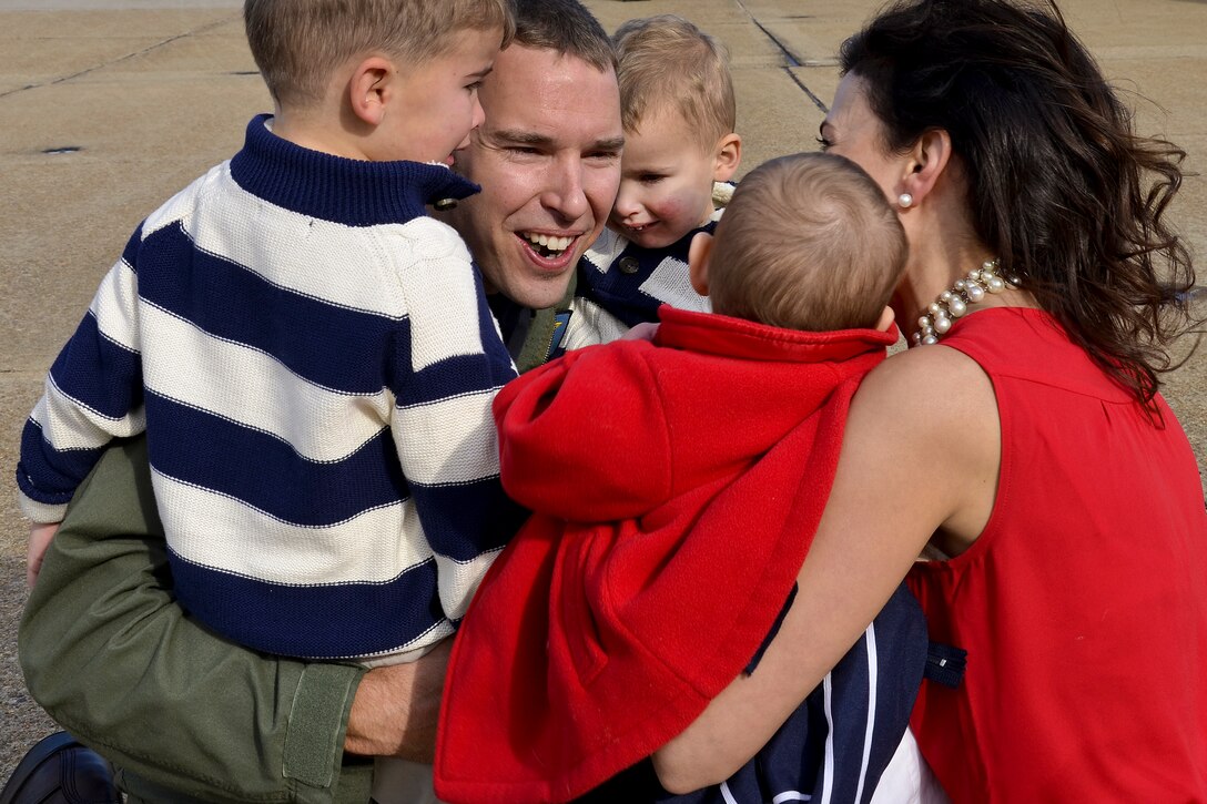 Navy Lt. Cmdr. Nate Lyon reunites with his wife and children during a homecoming celebration in Virginia Beach, Va., Dec. 18, 2012. Lyon, a member of Strike Fighter Squadron 83, returned to Naval Air Station Oceana after a six-month deployment to support Operation Enduring Freedom, maritime security operations and theater security cooperation efforts.  
