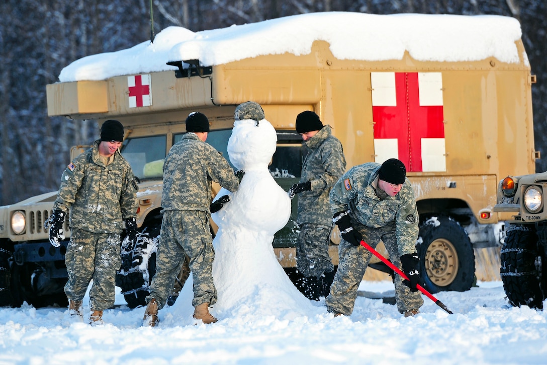 Left to right: U.S. Army Pfc. Christopher Moore, U.S. Army Pvt. Jordan Villa, U.S. Army Sgt. John-Paul Gorcyca, and U.S. Army Pfc. Sean Spacek, build a snowman while waiting for a parachute drop of heavy equipment on Malamute Drop Zone on Joint Base Elmendorf-Richardson, Alaska, Dec. 13, 2012. Moore, Villa, Gorcya, and Spacek are assigned to the 6th Engineer Battalion, Combat, Airborne.  
