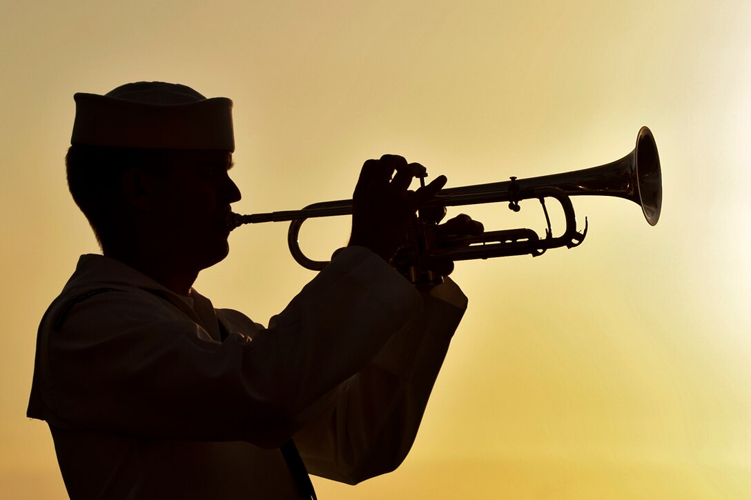 Navy Petty Officer 3rd Class Shelby Tucci plays Taps during a sunset ceremony at the USS Utah Memorial, Joint Base Pearl Harbor-Hickam, Hawaii, Dec. 6, 2012. The Utah was sunk during the surprise Japanese attack on Pearl Harbor on Dec. 7, 1941. Tucci is assigned to the Pacific Fleet Band. 
