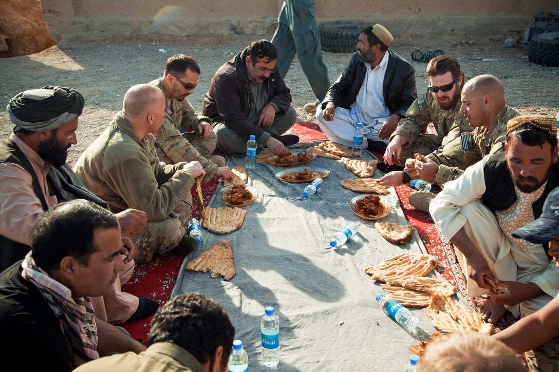 Afghan local and national policemen talk with coalition force members during a meeting to discuss self-sustainment of the police forces in Afghanistan's Farah province, Dec. 3, 2012.  
