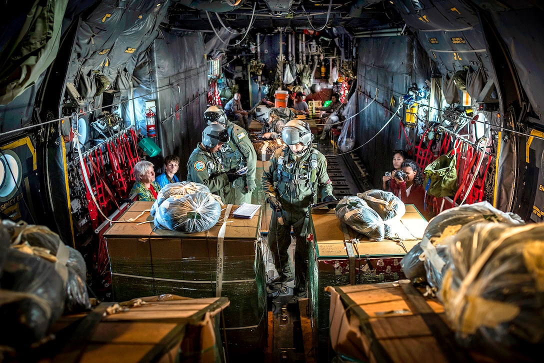 U.S. Air Force loadmasters inside a C-130H aircraft prepare humanitarian goods destined for remote islands within the Micronesian Islands during the 61st anniversary of Operation Christmas Drop, Dec. 11, 2012. The loadmasters, are assigned to the 36th Airlift Squadron, Yokota Air Base, Japan.  
