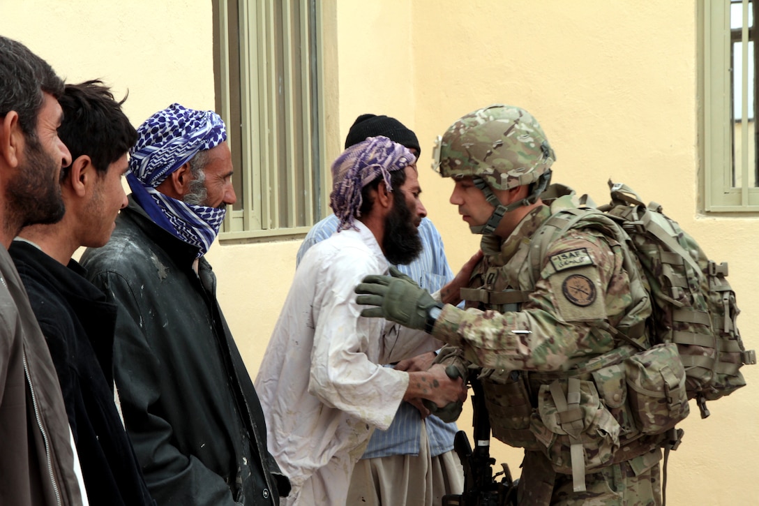 U.S. Navy Lt. Ronnie Mojzis, right, says goodbye to construction workers who helped construct the new Bakwa district center in western Afghanistan after assessing their construction efforts, Nov. 27, 2012. The teams mission is to train, advise, and assist Afghan government leaders at the municipal, district, and provincial levels in Farah province.  
