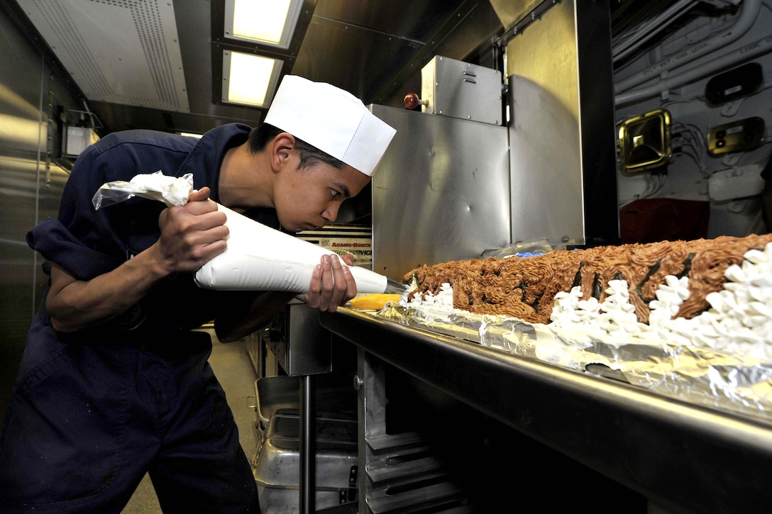 Navy Petty Officer 3rd Class Job David Santiago frosts a cake aboard the USS Jason Dunham on Thanksgiving in the Arabian Sea, Nov. 22, 2012. The Jason Dunham is deployed to the U.S. 5th Fleet area of responsibility conducting maritime security and support missions for Operation Enduring Freedom.  
