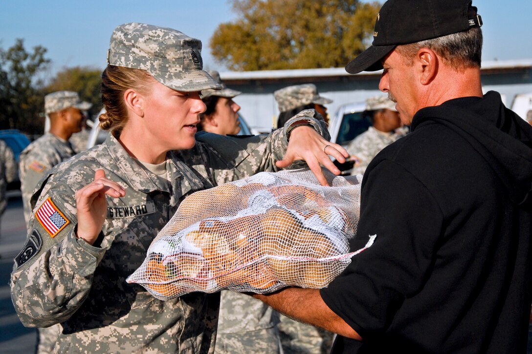 Army Sgt. 1st Class Julie Steward examines a bag of potatoes before crews load it into a vehicle during the Thanksgiving basket giveaway at the Food Care Center in Kileen, Texas, Nov. 20, 2012. Steward is assigned to the 79th Ordnance Battalion.  
