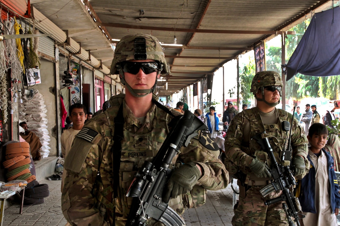 U.S. Army Capt. Jacob Estrada, right, and Spc. Devont Perkins patrol a local shopping area during a key leader meeting in Farah City, Afghanistan, Nov. 20, 2012. The soldiers are assigned to Provincial Reconstruction Team Farah, which trains, advises and assists Afghan government leaders in Farah province.  
