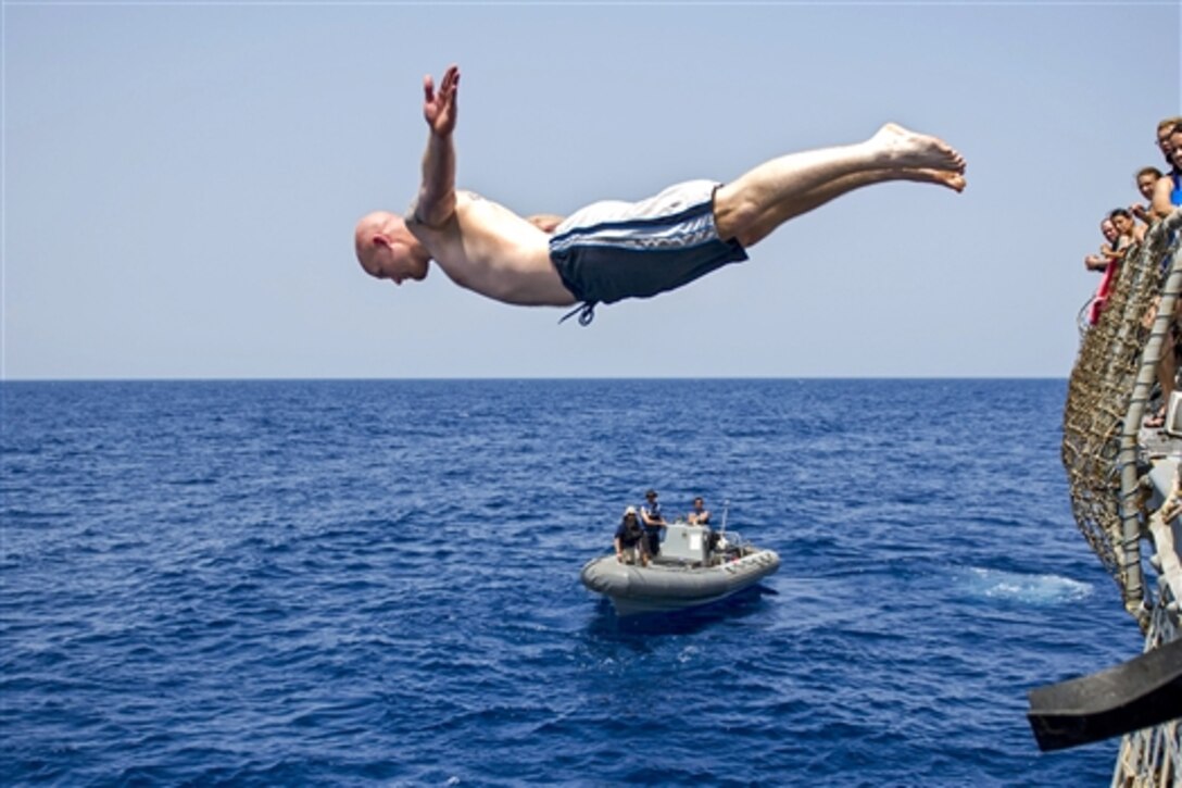 U.S. Navy Petty Officer 1st Class Robert Creedon dives into the Arabian Sea during an all-hands swim call aboard the USS Roosevelt, May 15, 2014. Creedon is a fire controlman. The Roosevelt is deployed as a part of the George H.W. Bush Carrier Strike Group supporting maritime security operations and theater security efforts in the U.S. 5th Fleet area of responsibility. 