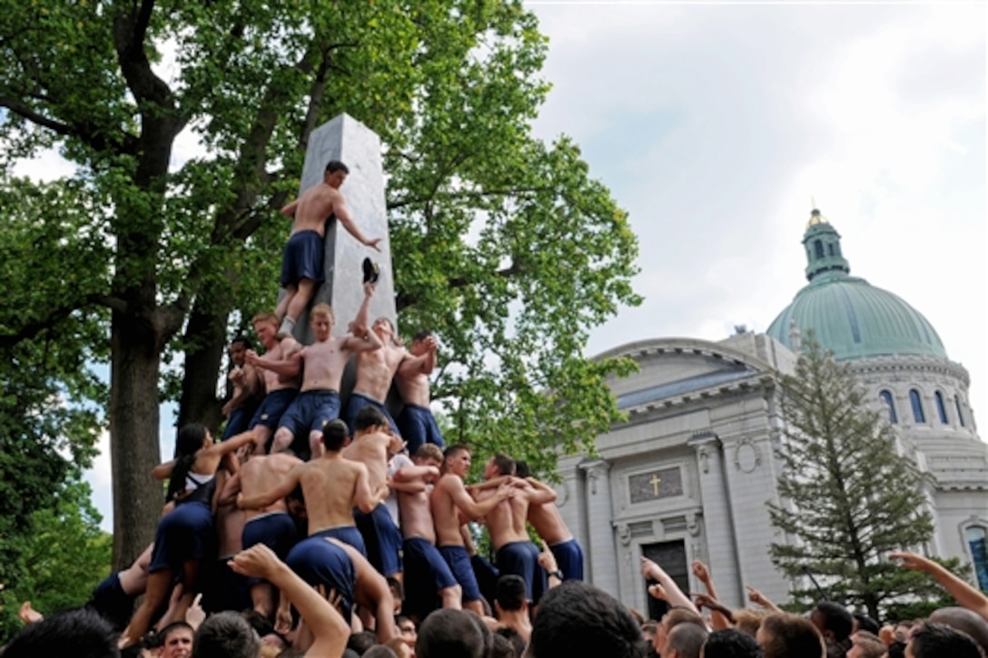Naval Academy freshmen, or plebes, climb the Herndon Monument, in Annapolis, Md., May 19, 2014, in a tradition symbolizing the successful completion of the midshipmen freshman year. The Class of 2017 must use teamwork, strategy and communication to climb the 21-foot-tall monument and replace the traditional plebe cover at the top with a midshipman's cover. They completed the Herndon Climb in 2:19:35. 