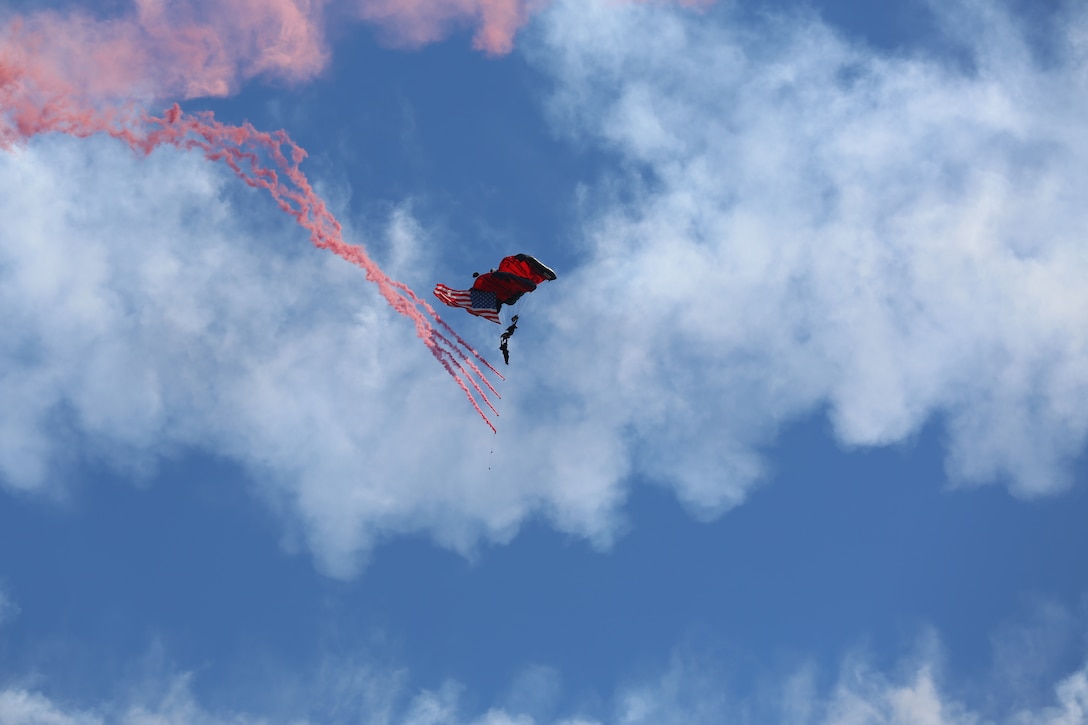 A soldier with the United States Army Special Operations Command Parachute Demonstration Team drags a train of smoke grenades during the 2014 MCAS Cherry Point Air Show May 17. During the air show the soldiers performed various free-fall jumps using ram-air parachutes allowing them to jump with up to 100 pounds of additional equipment. The team is also known as the Black Daggers.  