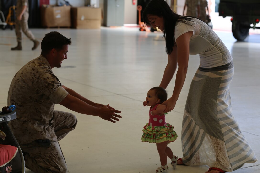 Sgt. Nathaniel D. Shrupp, with Marine Tactical Electronic Warfare Training Squadron 1, greets his wife and daughter after returning to Cherry Pooint May 19 following a four-week deployment to Naval Air Station Key West, Fla. During the deployment, the Marines conducted Fleet Replacement Squadron production training, which helps student pilots complete qualifications needed to transition into the Fleet Marine Force. Schrupp is an aircraft ordnance technician with the Squadron.