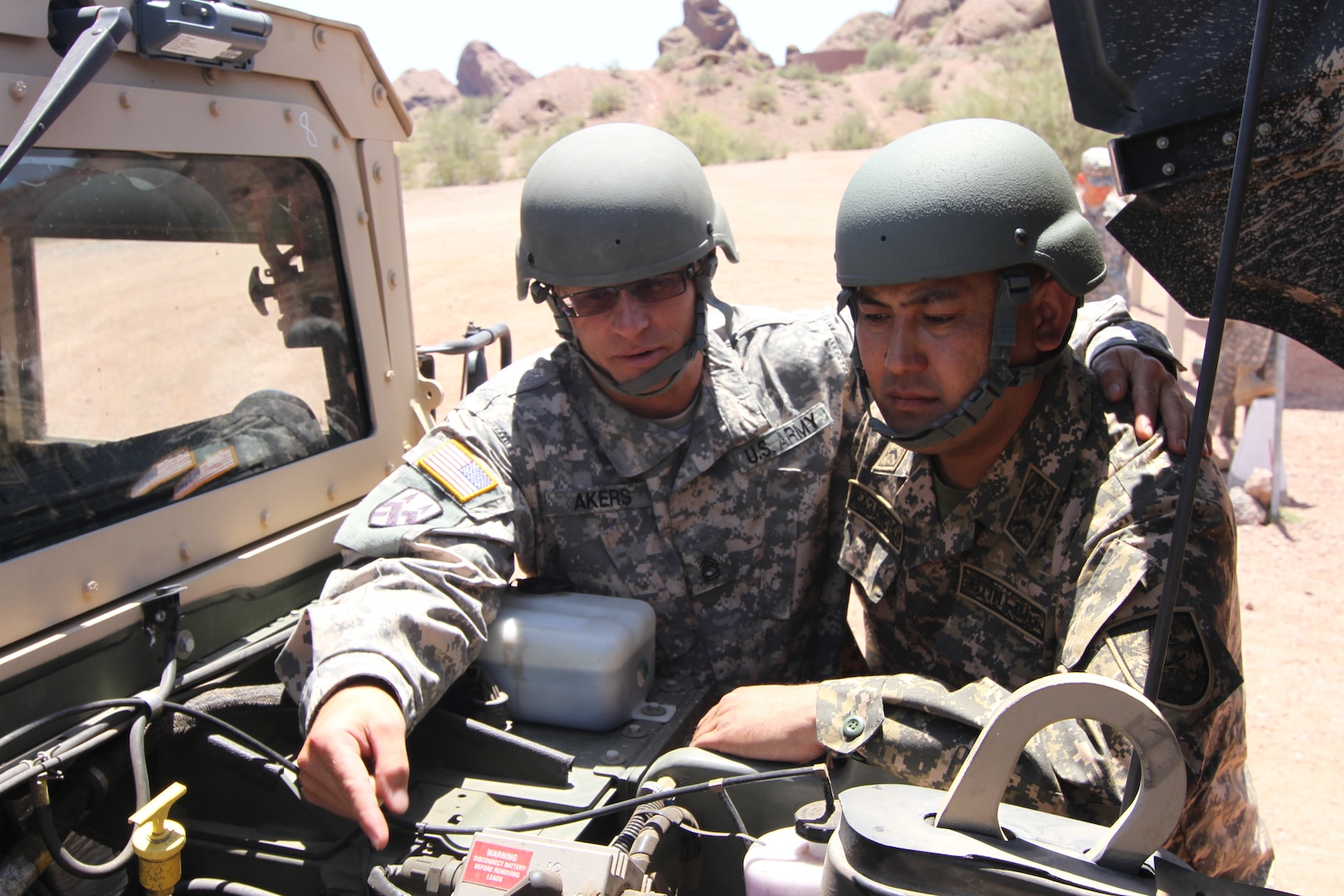 Army Sgt 1st Class James Akers, left, and Kazakhstan Army Staff Sgt. Dumon Moldrakhman, discuss high mobility multipurpose wheeled vehicle, or Humvee, maintenance information at Papago Park Military Reservation in Phoenix May 12 - 16. Since 1994 the Arizona National Guard has partnered with Kazakhstan as part of the National Guard's State Partnership Program. 