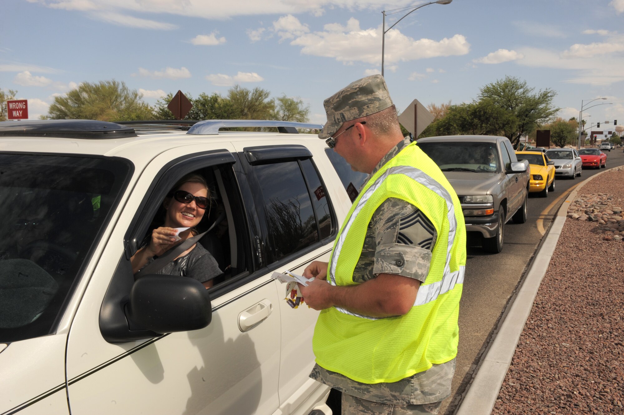 U.S. Air Force Chief Master Sgt. Brian Morgan, 357th Aircraft Maintenance Unit superintendent, wishes departing Airmen and their family members a happy Memorial Day weekend at the Craycroft Gate at Davis-Monthan Air Force Base, Ariz., May 22, 2014. D-M leadership was present at each gate to remind Airmen to stay safe over the long weekend. (U.S. Air Force photo by Airman 1st Class Chris Drzazgowski/Released)