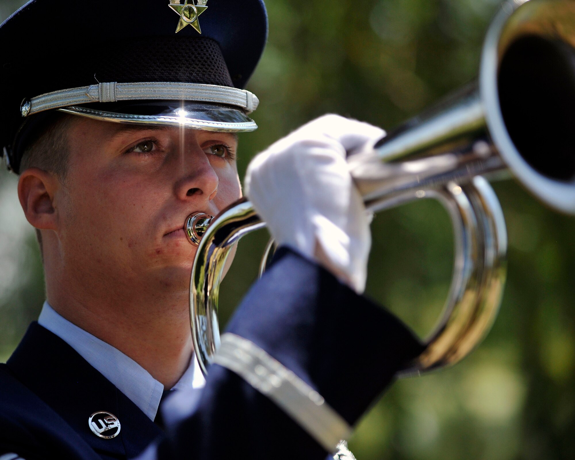 U.S. Air Force Senior Airman Alexander Bradshaw, Mile High Honor Guard plays taps on a ceremonial bugle during military funeral honors July 11, 2012, at Fort Logan National Cemetery in Denver. The base honor guard performs final military honors at nearly 570 funerals per year and is the face of the United States Air Force to many families who have lost their loved ones. (U.S. Air Force photo by Tech. Sgt. Wolfram Stumpf/Released)