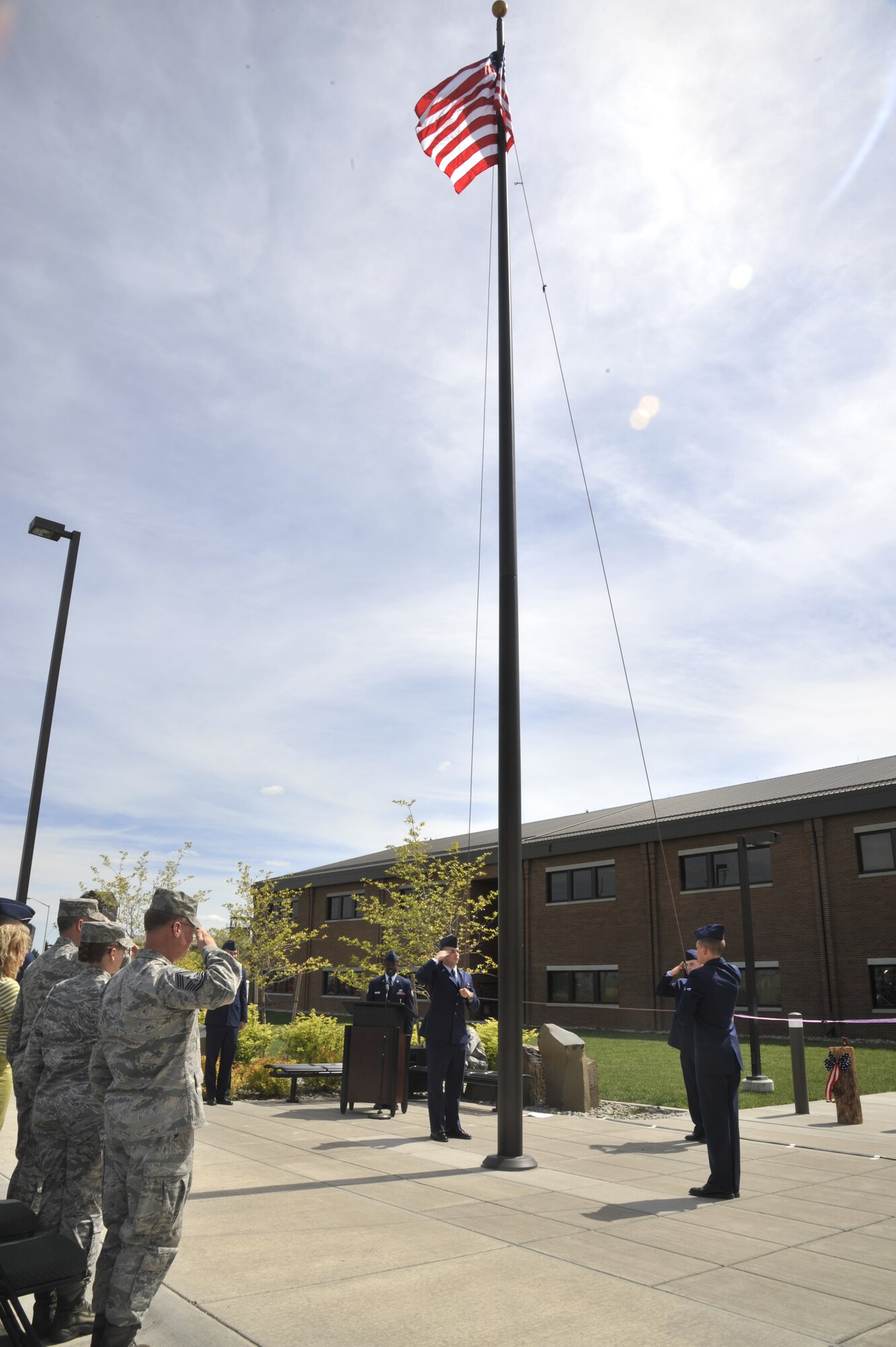 Team Fairchild Honor Guard Airmen raise the flag prior to ribbon cutting a ceremony at Fairchild Air Force Base, Wash., May 21, 2014. This ribbon cutting ceremony was held to signal the official opening of the brand new 336th Training Group headquarters building. (U.S. Air Force photo by Senior Airman Mary O'Dell/Released)