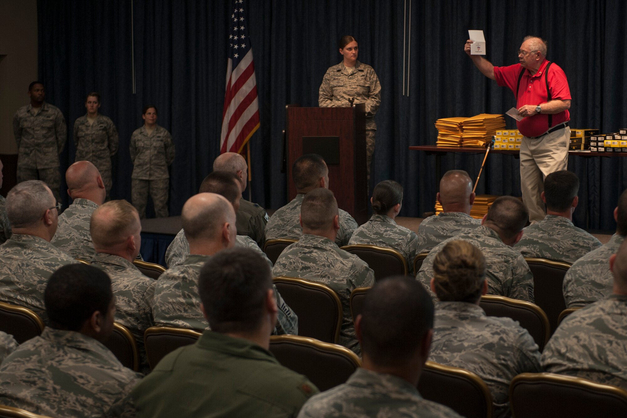 Graham Crutchfield holds a letter he personally signs and addresses to each recipient of a Buck Knife as he explains the Buck knife’s significance during a special commemoration ceremony distributing Buck Knives to service members who have served overseas in Afghanistan and Iraq at Fairchild Air Force Base, Wash., May 21, 2014. Crutchfield is a retired Marine who has dedicated countless hours in service to his brothers and sisters in arms. (U.S. Air Force photo by Staff Sgt. Benjamin W. Stratton/Released)