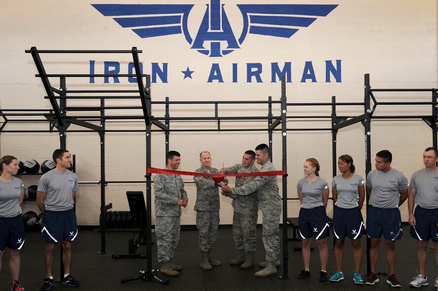 Left to right: Col. Andrew Gebara, 2nd Bomb Wing commander, Lt. Gen. Stephen Wilson, Air Force Global Strike commander, Staff Sgt. Jose Arriaga, and Senior Airman Pashala Lewis, 2nd Civil Engineer Squadron, cut a ribbon commemorating the opening of the new Iron Airman Fitness Center at Barksdale Air Force Base, La., May 22, 2014. Around 70 Airmen contributed to the renovation of the nearly 60 year-old building, formerly the Airman Leadership School Gymnasium. (U.S. Air Force photo/Tech. Sgt. Marie Brown)