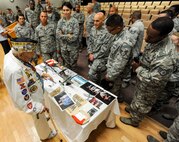 Pearl Harbor attack survivor retired Army SGT. Allen Bodenlos explains historical memorabilia to 15th Wing Airmen after his speech in the Hollister Auditorium on Joint Base Pearl Harbor-Hickam, May 21, 2014. Bodenlos was assigned to the 804th Engineer Aviation Battalion at Schofield Barracks as a bugle master on Dec. 7, 1941, when Pearl Harbor, Hickam Field and other parts of Oahu were attacked by the Imperial Japanese Navy. (U.S. Air Force photo/Tech. Sgt. Terri Paden)