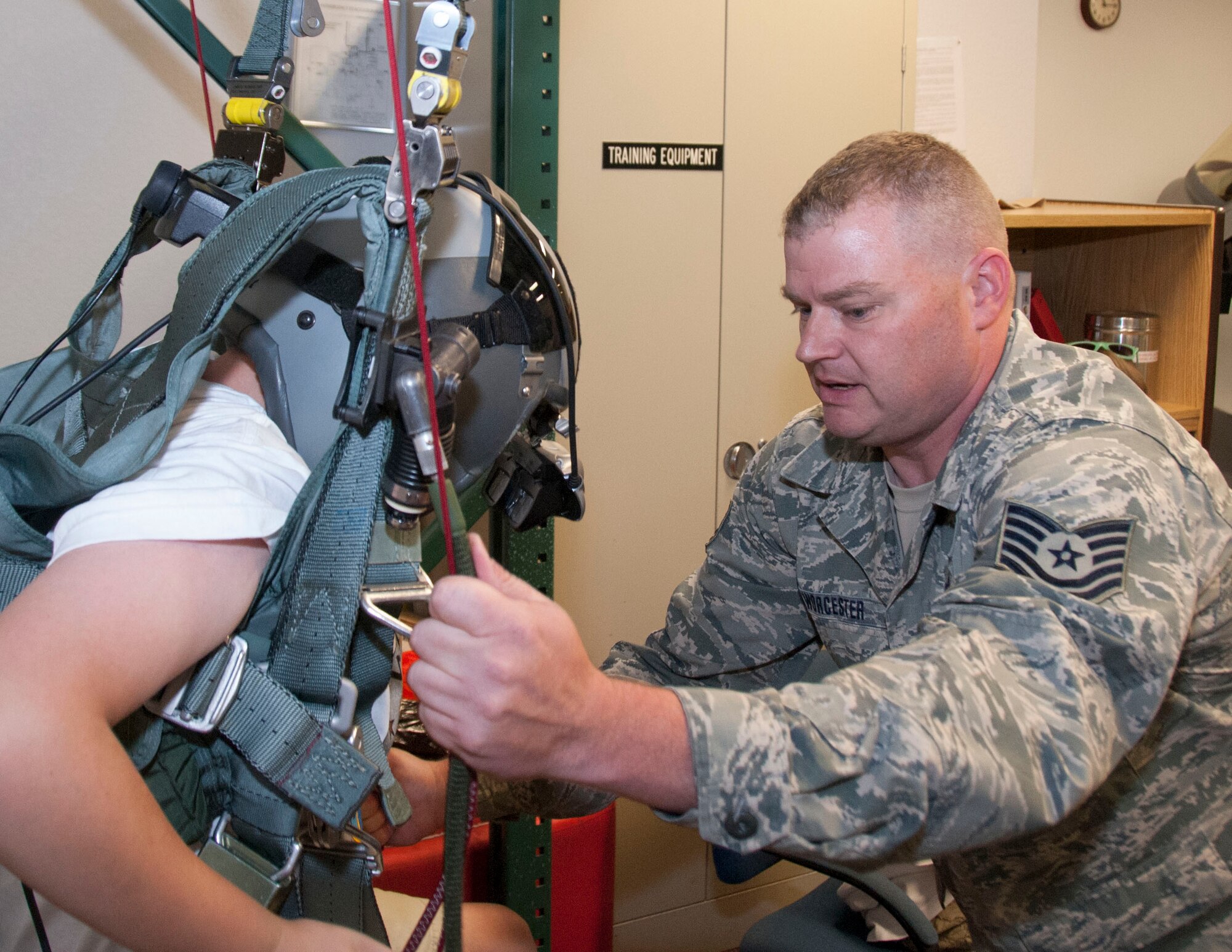 Tech. Sgt. Orland Worcester, an aircrew flight equipment technician, helps a fourth-grader fully engage a four-line jettison, helping him steer to safety in a Parachute Simulator Virtual Realty Trainer. The fourth grader was a member of Wright Flight, a Tucson-based, non-profit organization that educates middle-school students about aviation, and provided that they meet certain academic requirements and personal goals, rewards them with flights in small-engine aircraft and visits to air base units like they did May 16 at the 162nd Wing in Tucson, Ariz. (U.S. Air National Guard photo by Staff Sgt. Erich B. Smith/Released)